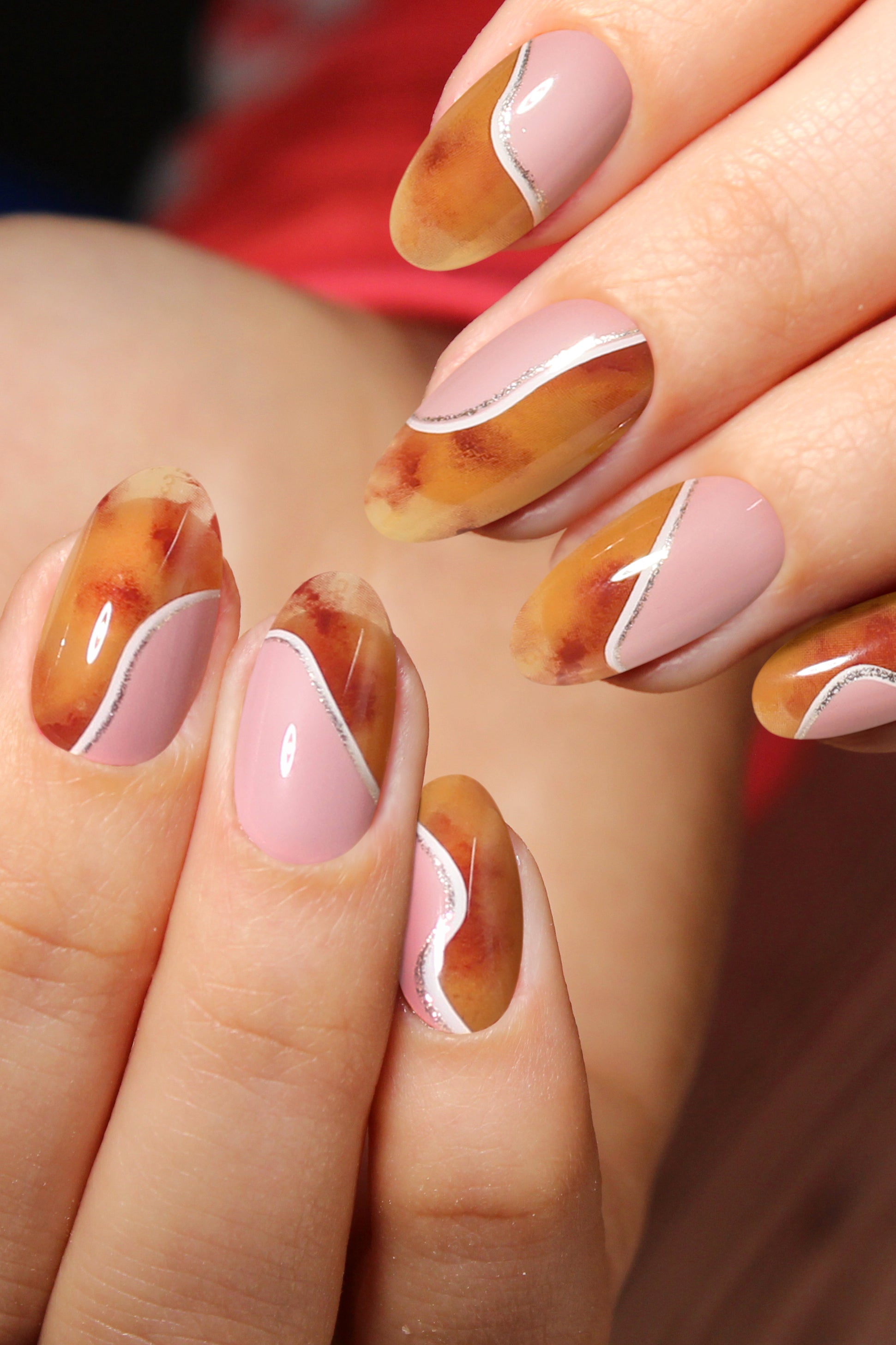 Mars Press-On Nails featuring vintage amber marble design with coral pink accents and shimmering line detail.