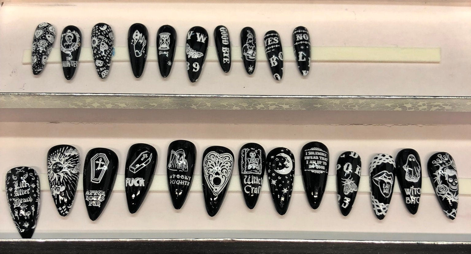 A set of 24 Ouija Board themed press on nails in stiletto, coffin, and short styles, showcasing unique designs and colors.