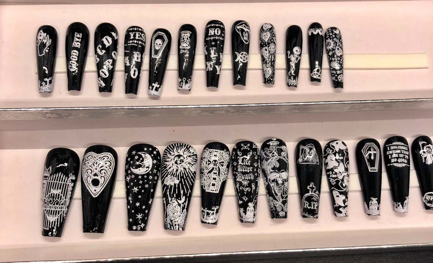 A set of 24 Ouija Board themed press on nails in stiletto, coffin, and short styles, showcasing unique designs and colors.