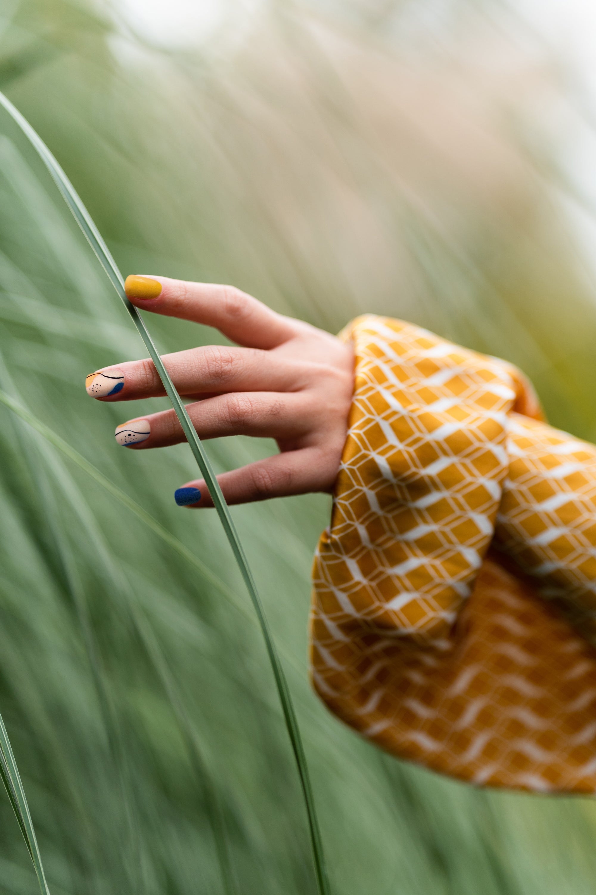 Tangerine Garden press-on nails featuring vibrant tangerine color with navy accents and cream touches, designed for a stylish manicure.