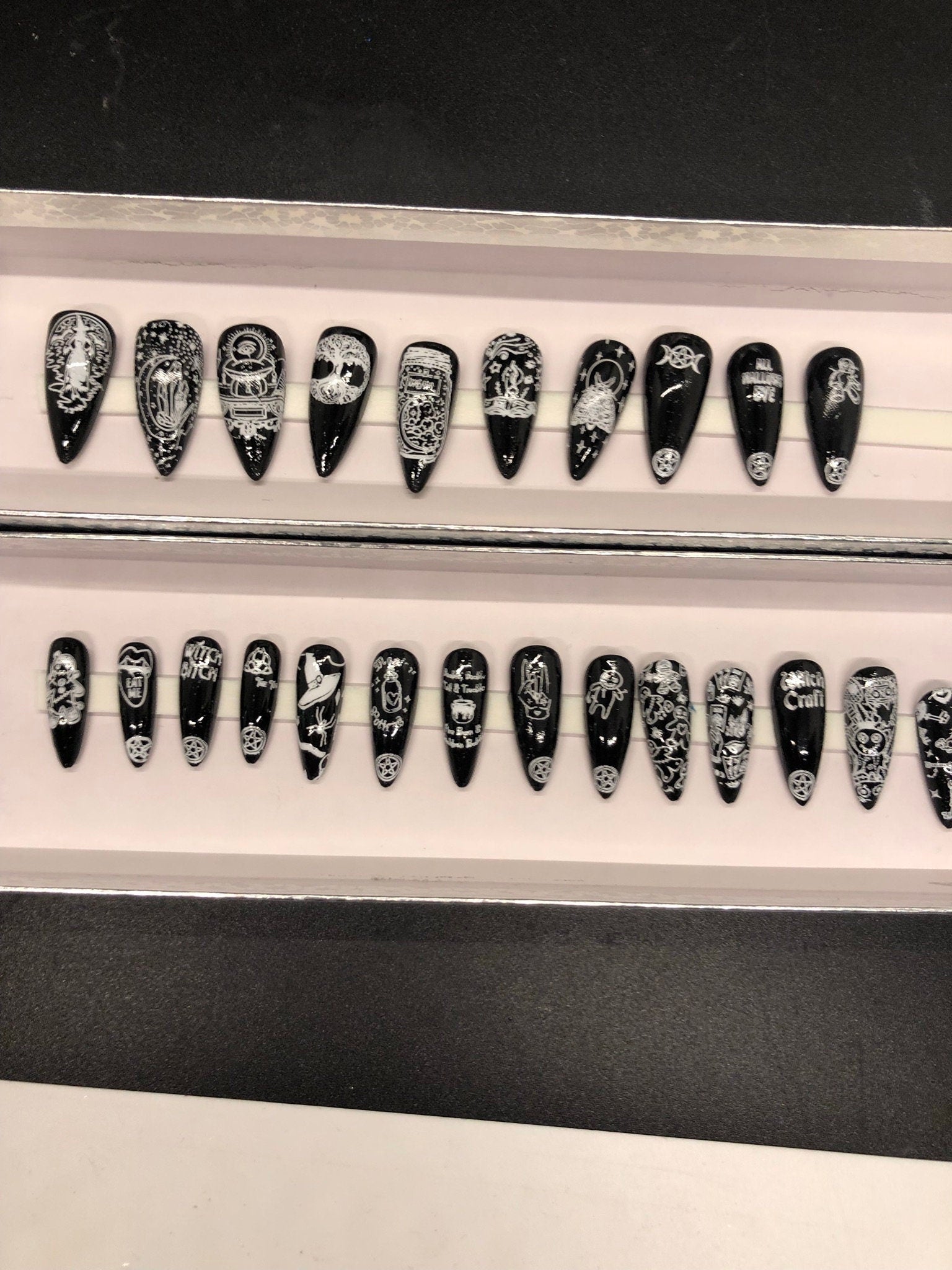 A set of 24 witch-themed press on nails in various styles including stiletto, coffin, and short, showcasing unique designs and colors.