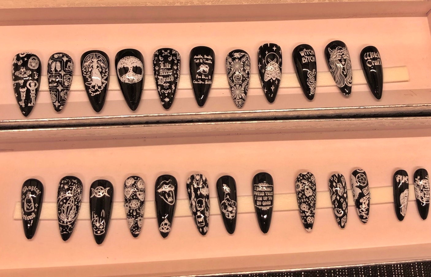 A set of 24 witch-themed press on nails in various styles including stiletto, coffin, and short, showcasing unique designs and colors.