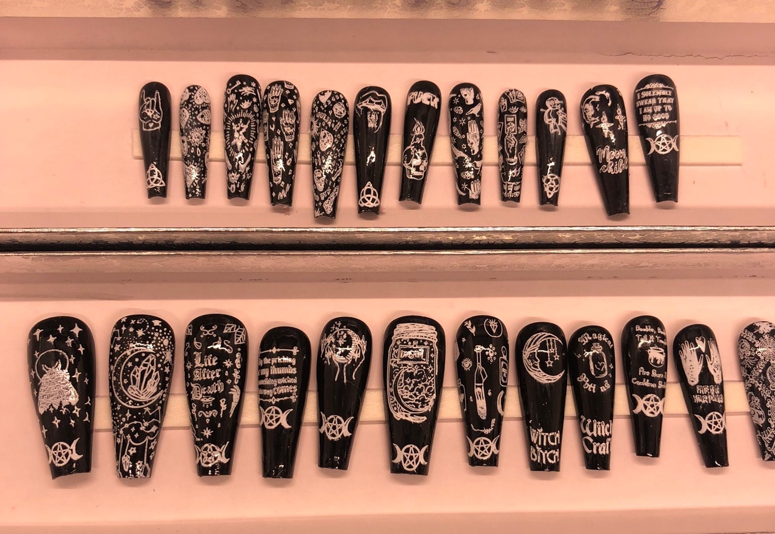 A set of 24 witch-themed press on nails in various styles including stiletto, coffin, and short, showcasing unique designs and colors.