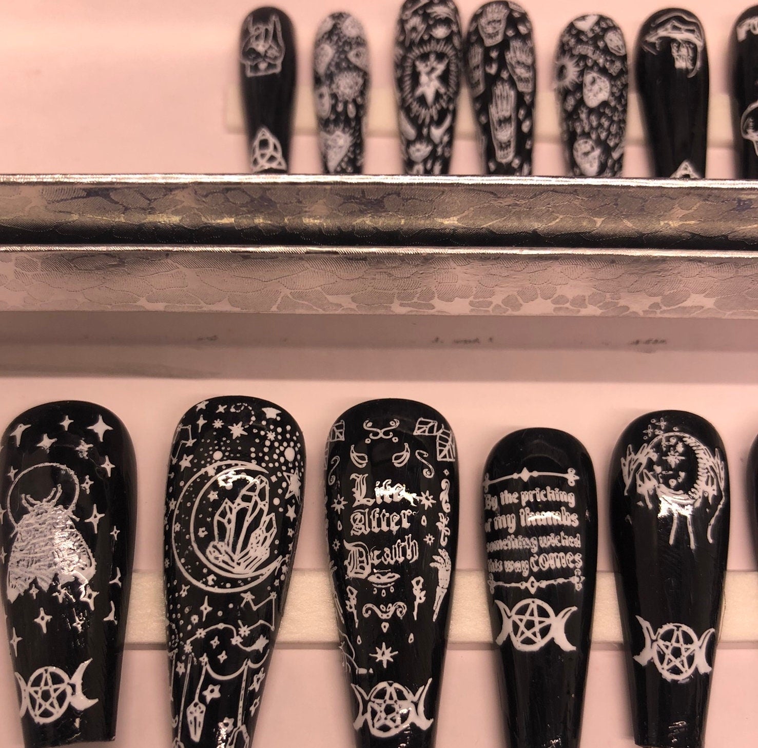 A set of 24 witch-themed press on nails in various styles including stiletto, coffin, and short, showcasing unique designs and colors.