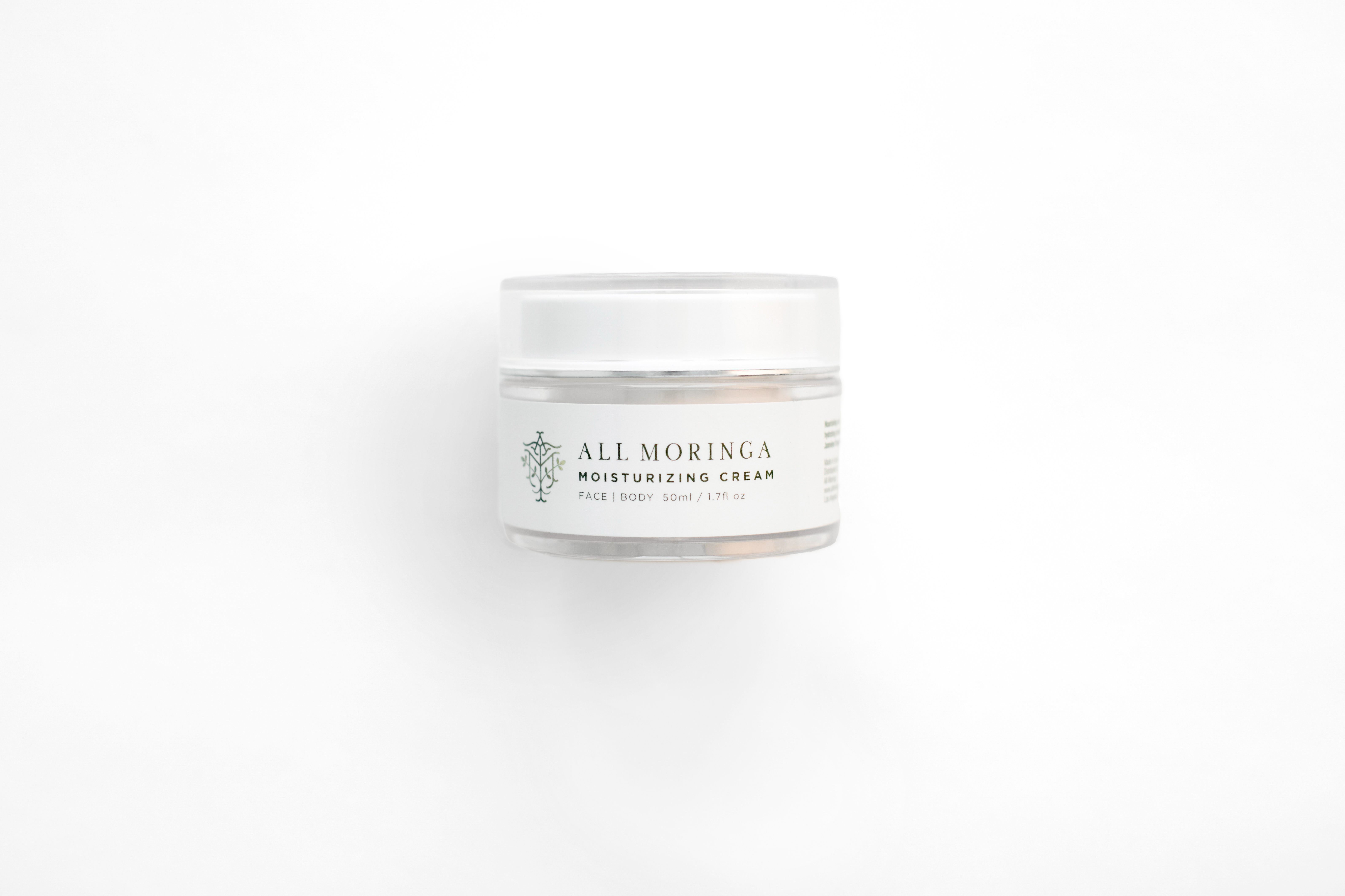 A jar of unique Moringa Moisturizing Face Cream with a soft, silky texture, showcasing its natural ingredients and white color.