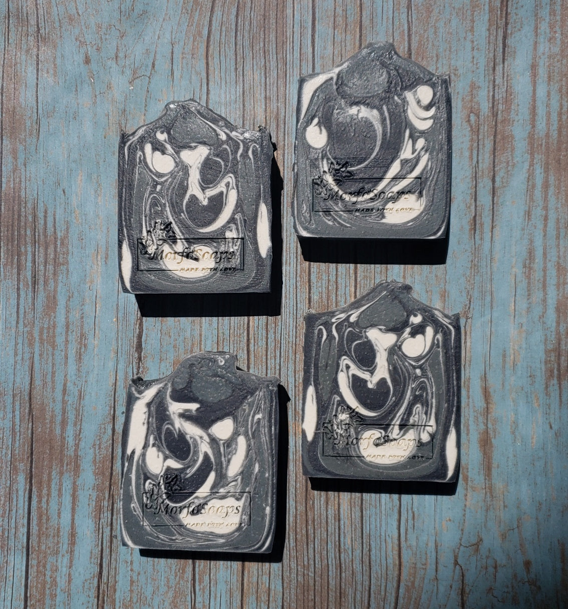 A bar of MorfoSoaps' All Natural Eucalyptus Soap, showcasing its unique color and texture, made with eucalyptus oil and activated charcoal.