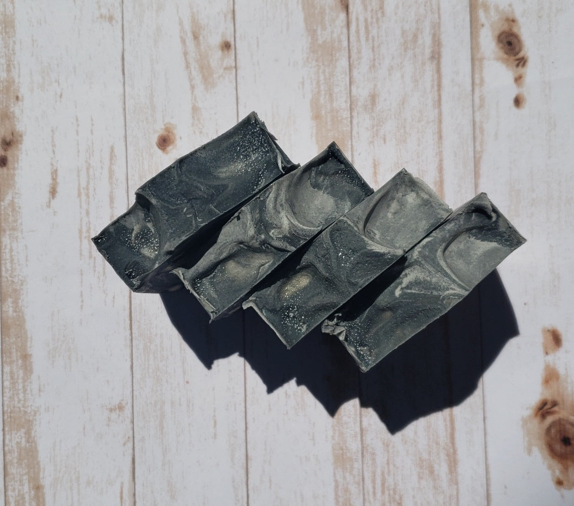 A bar of MorfoSoaps' All Natural Eucalyptus Soap, showcasing its unique color and texture, made with eucalyptus oil and activated charcoal.