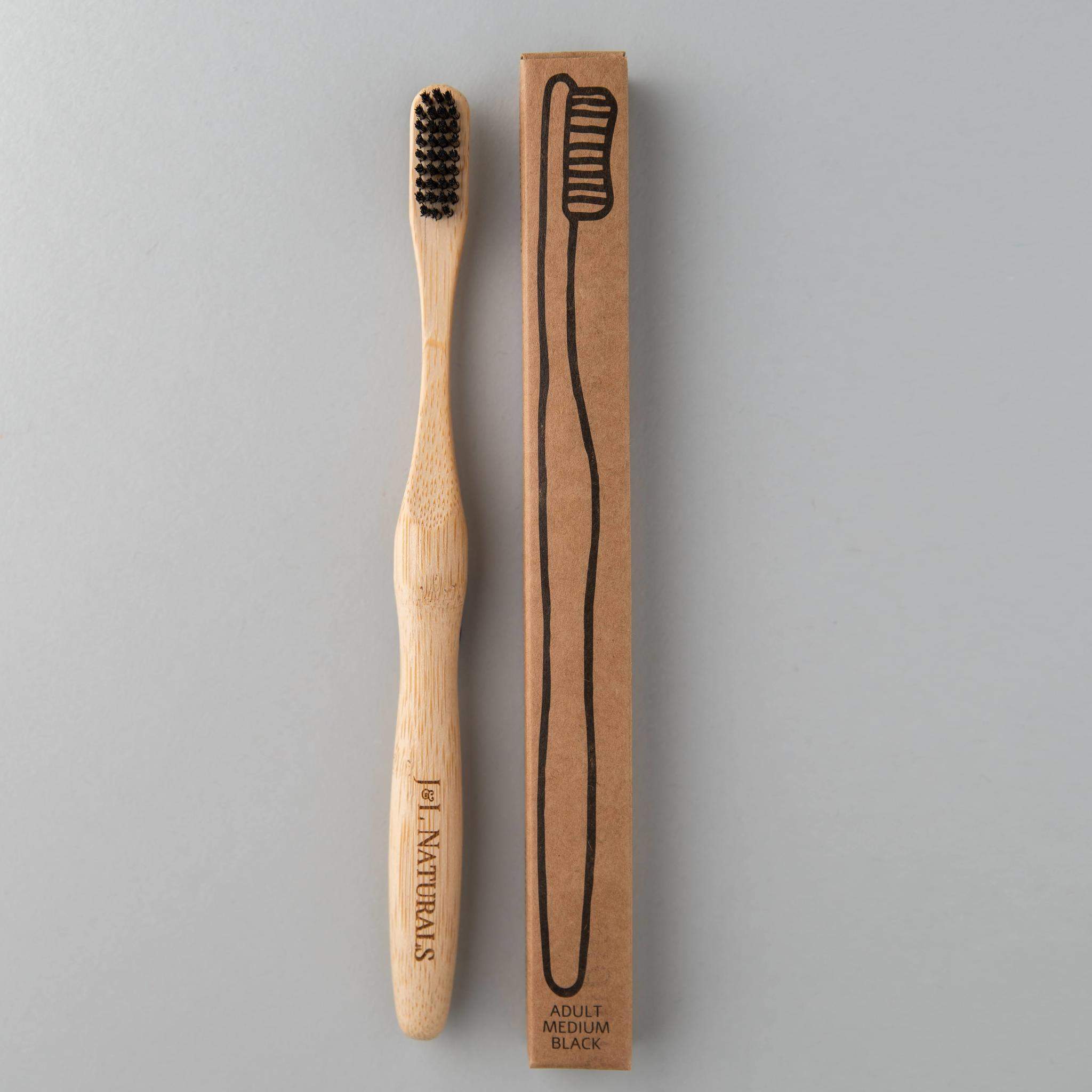 A bamboo toothbrush with medium wavy bristles and an ergonomic handle, available in various colors including black, white, natural, and rainbow.