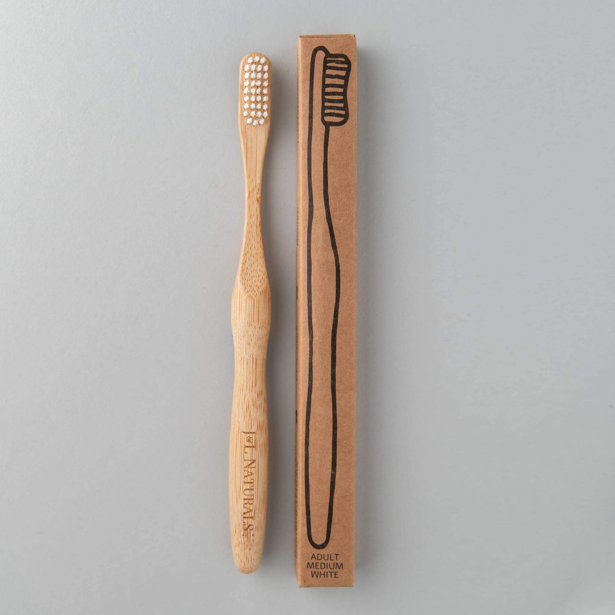 A bamboo toothbrush with medium wavy bristles and an ergonomic handle, available in various colors including black, white, natural, and rainbow.