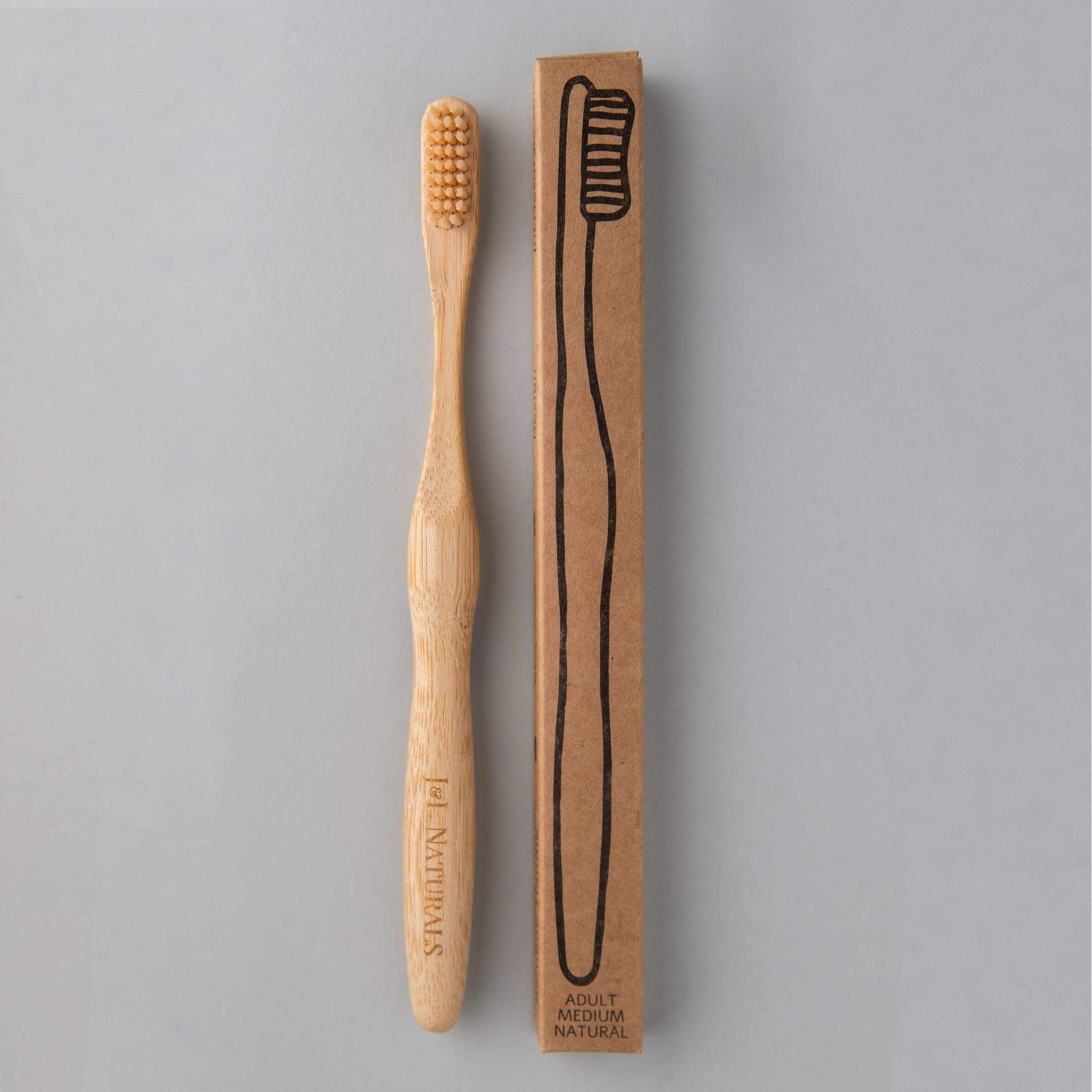 A bamboo toothbrush with medium wavy bristles and an ergonomic handle, available in various colors including black, white, natural, and rainbow.