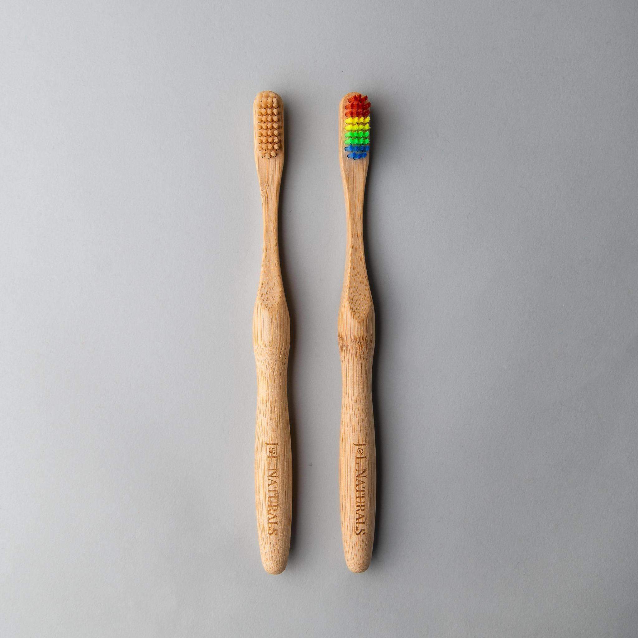 Two bamboo toothbrushes with ergonomic handles and medium wavy bristles, available in various colors.