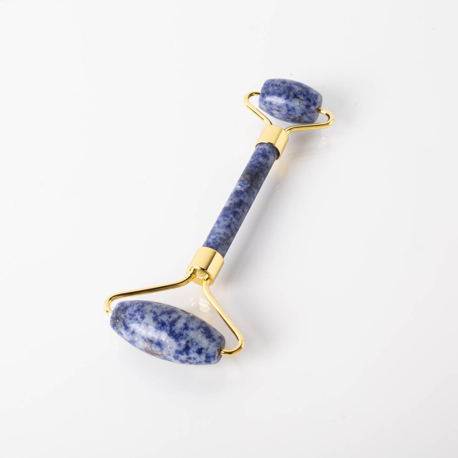 Holysticspa Blue Sodalite Face Roller on a marble surface, showcasing its beautiful blue gemstone and dual roller design.