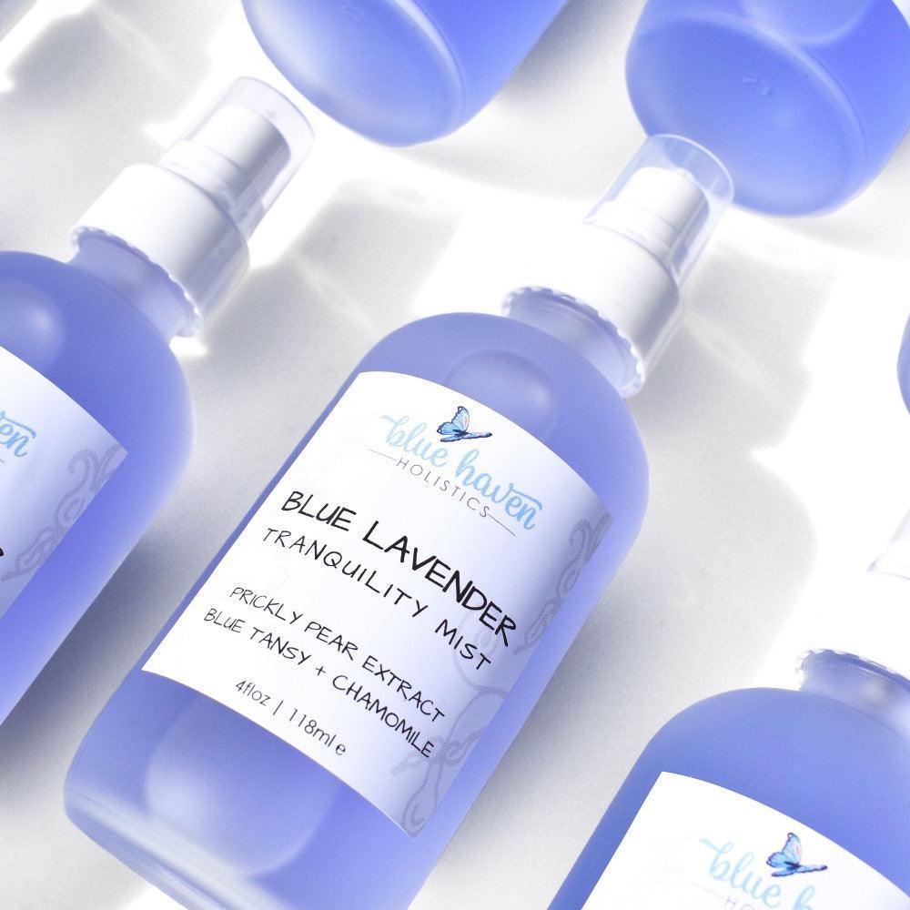 Blue Tansy Hydrating Face Mist bottle with a calming blue hue, surrounded by lavender and chamomile flowers, showcasing its natural ingredients.