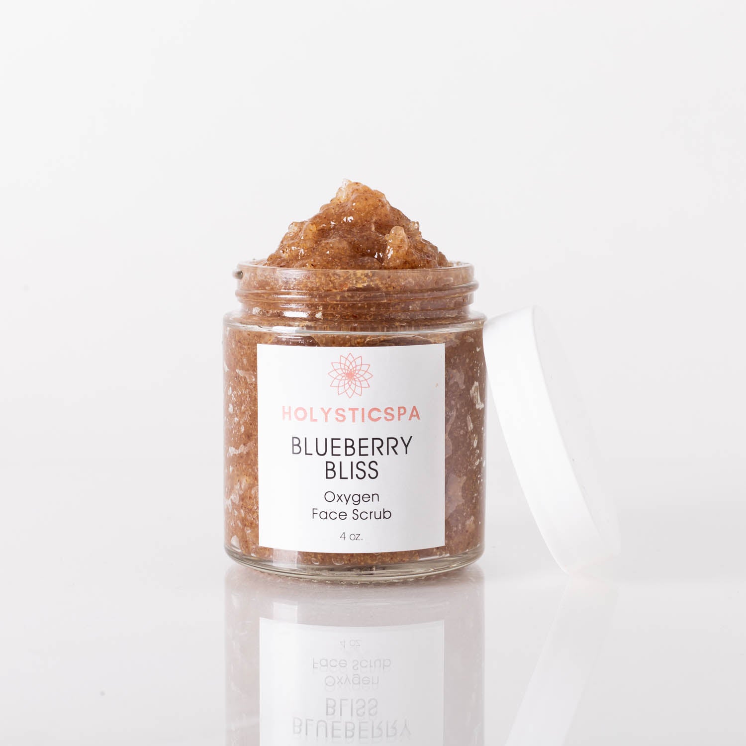 Blueberry Bliss Face Scrub in a jar with blueberries and cranberries around it, showcasing its natural ingredients.