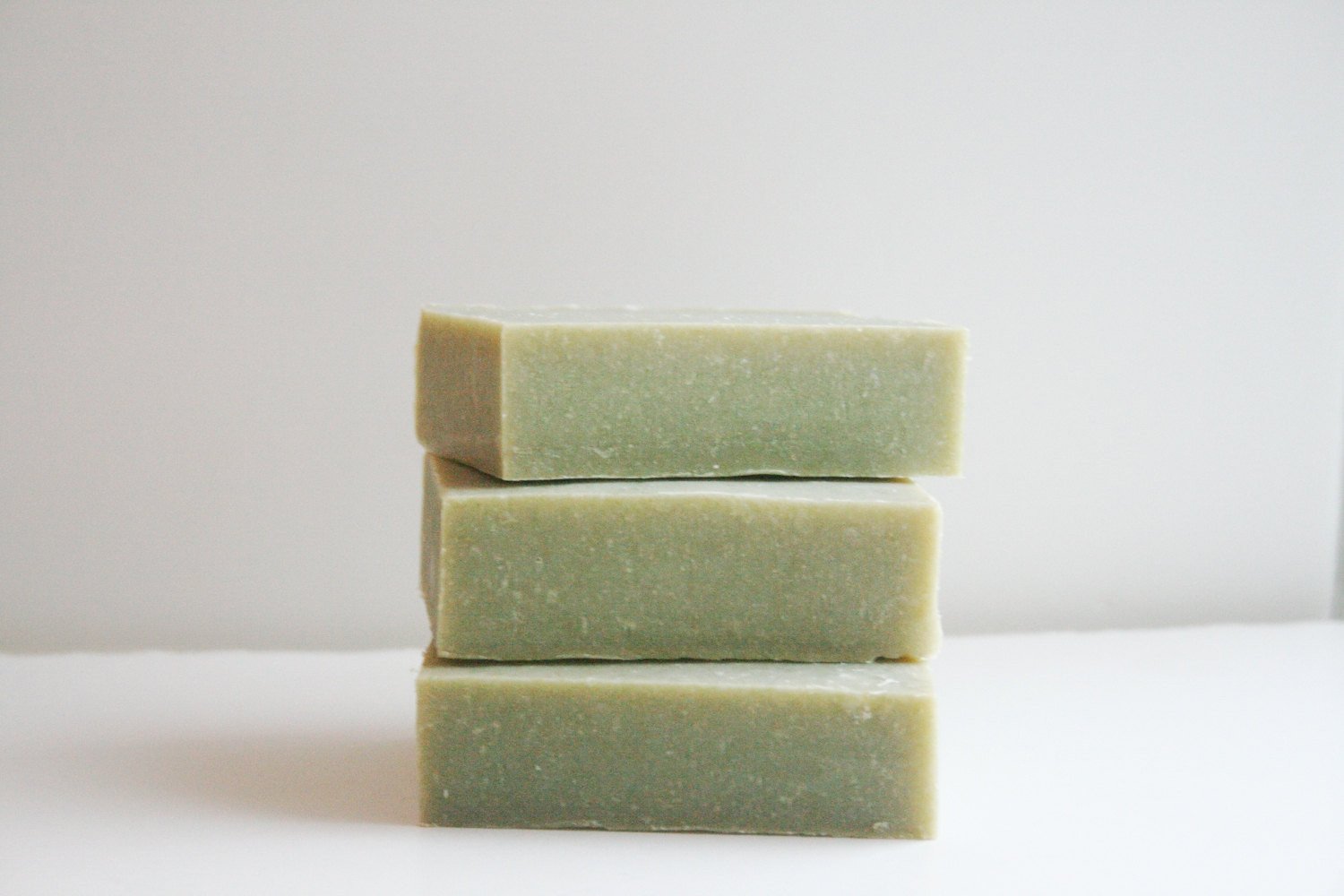 Cedarwood Sage Soap bar with natural green color, showcasing its woodsy scent and organic ingredients.