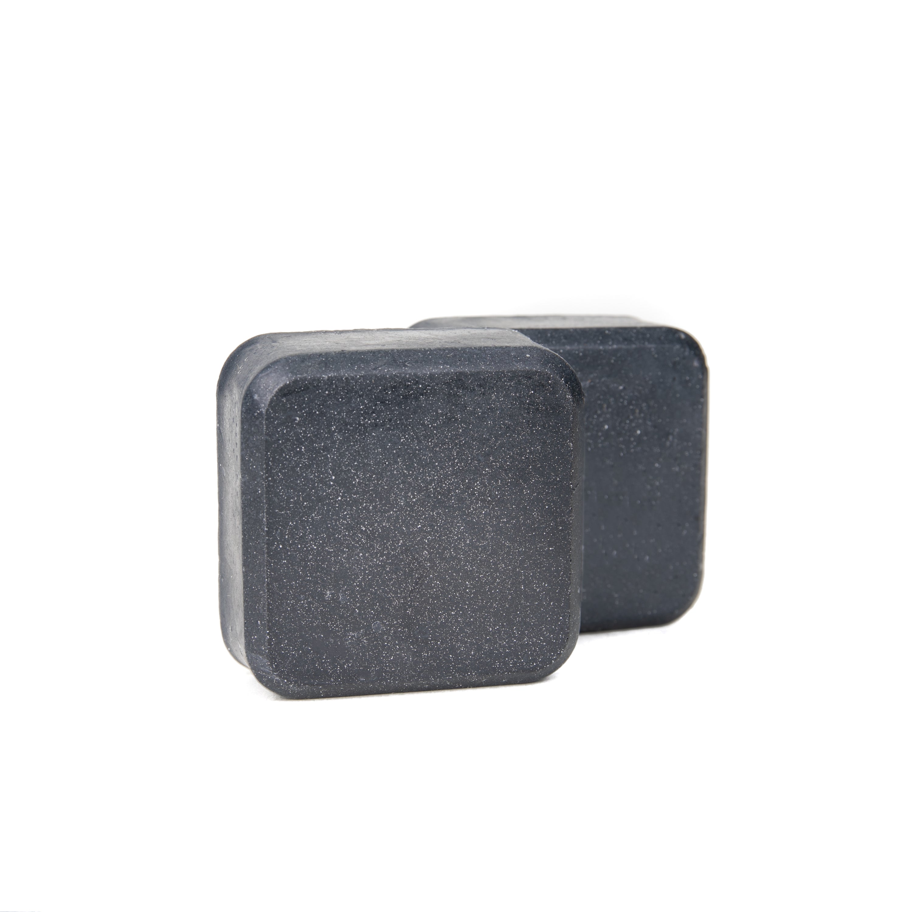 Charcoal Face & Body Soap with activated charcoal, green tea extract, and turmeric, displayed on a wooden surface.