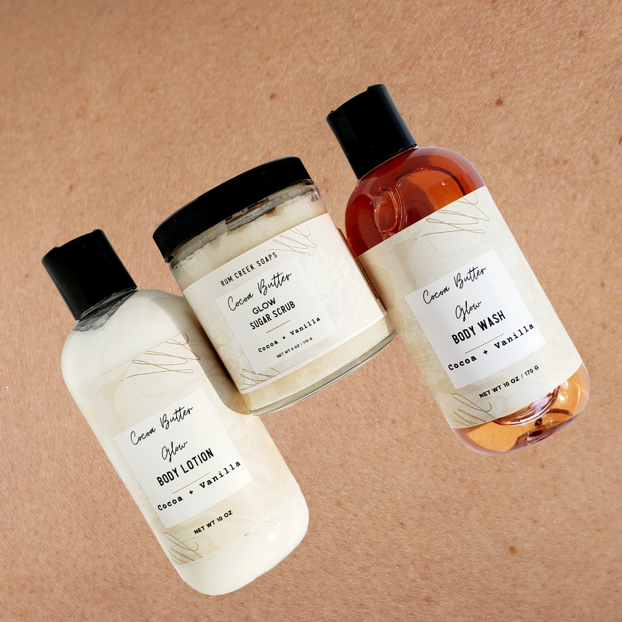 Cocoa Butter Glow Skincare Set including body wash, lotion, and sugar scrub in elegant packaging, showcasing a rich cocoa butter theme.