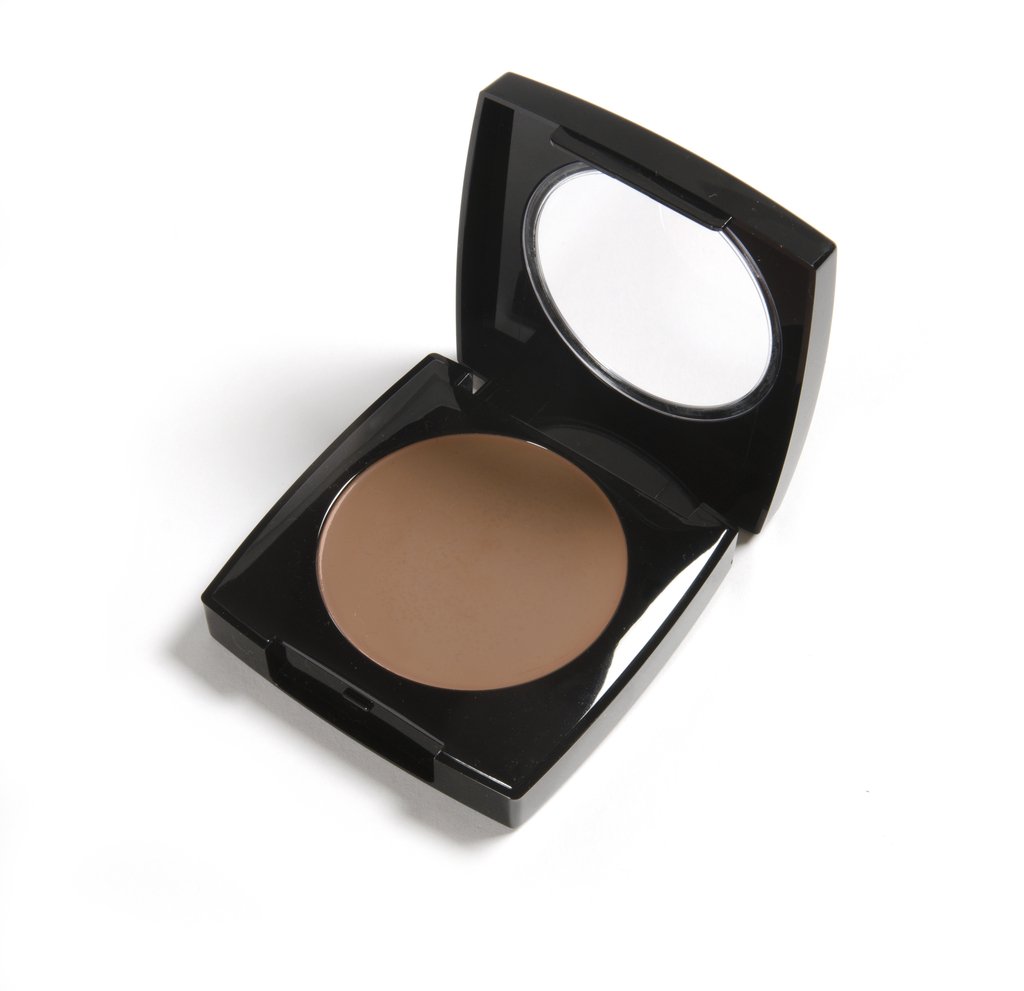 Danyel's Tropical Bronze Foundation in a compact, showcasing its creamy texture and deep olive shade for flawless coverage.