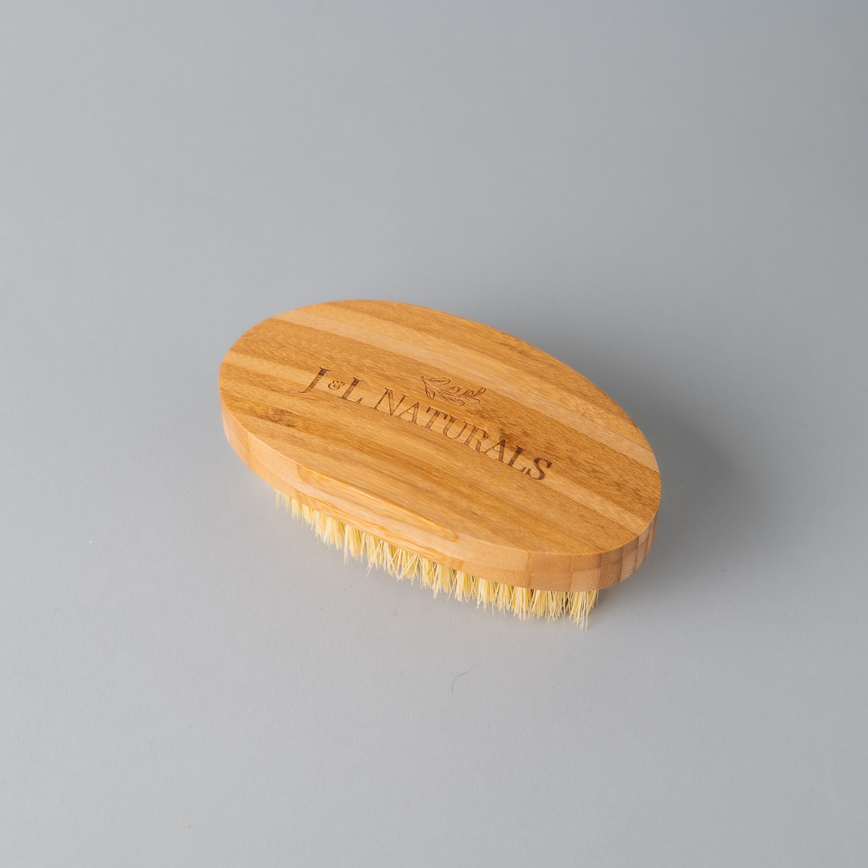 A natural Dry Brush made from bamboo and sisal fibers, designed for exfoliating and rejuvenating skin.