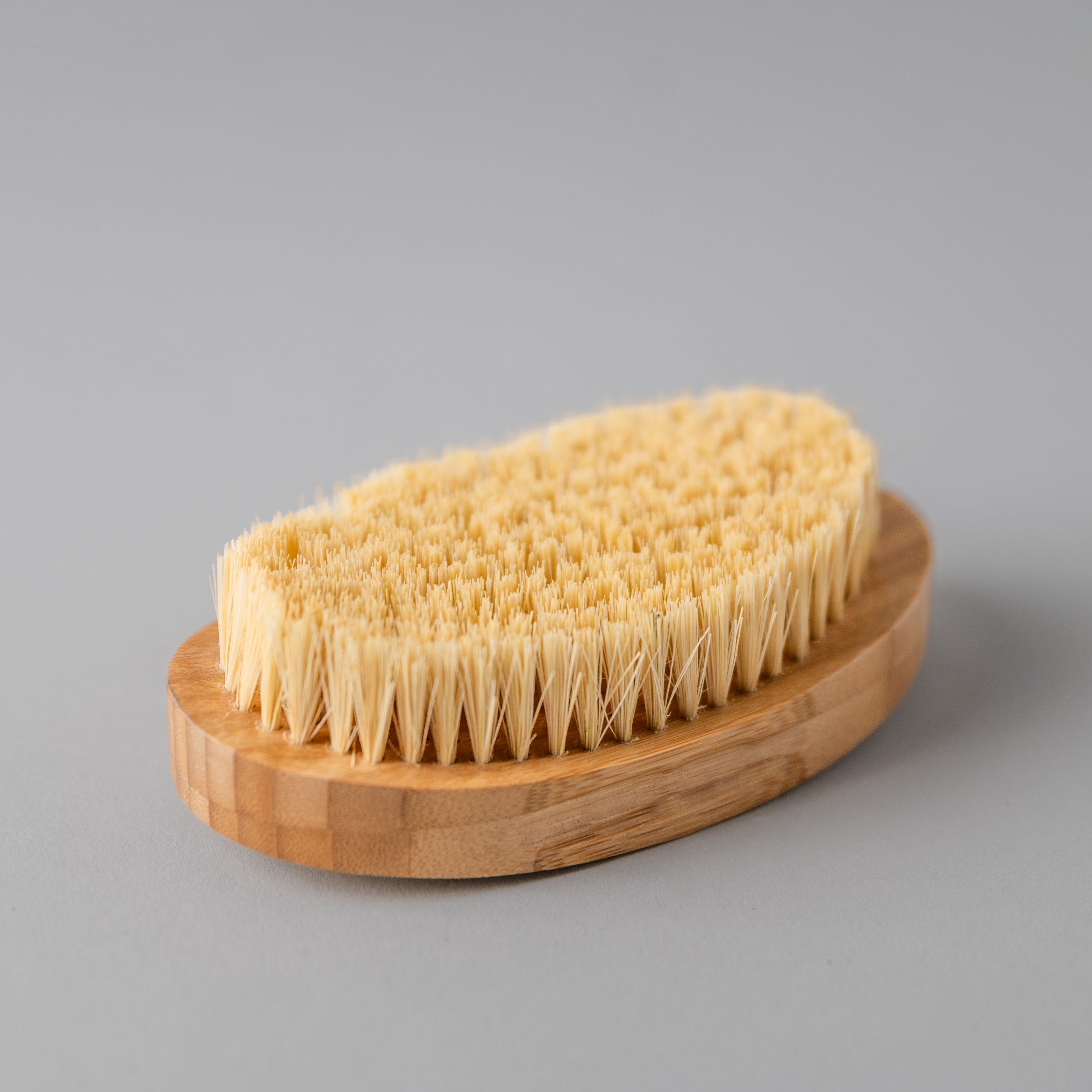 A natural Dry Brush made from bamboo and sisal fibers, designed for exfoliating and rejuvenating skin.