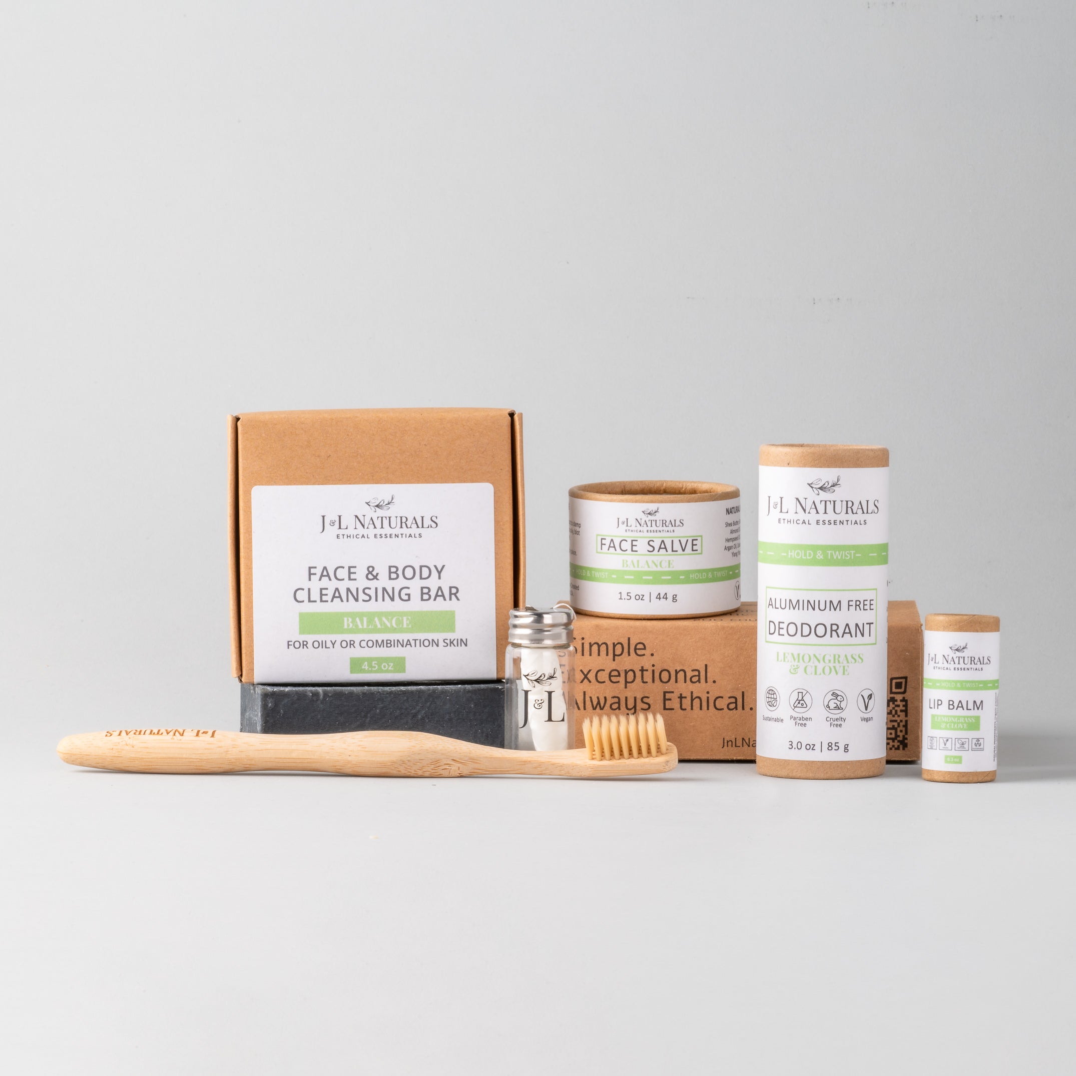 Essentials Self Care Kit featuring 7 skincare products including cleansing bar, face salve, lip balm, deodorant, bamboo toothbrush, floss, and cotton buds.