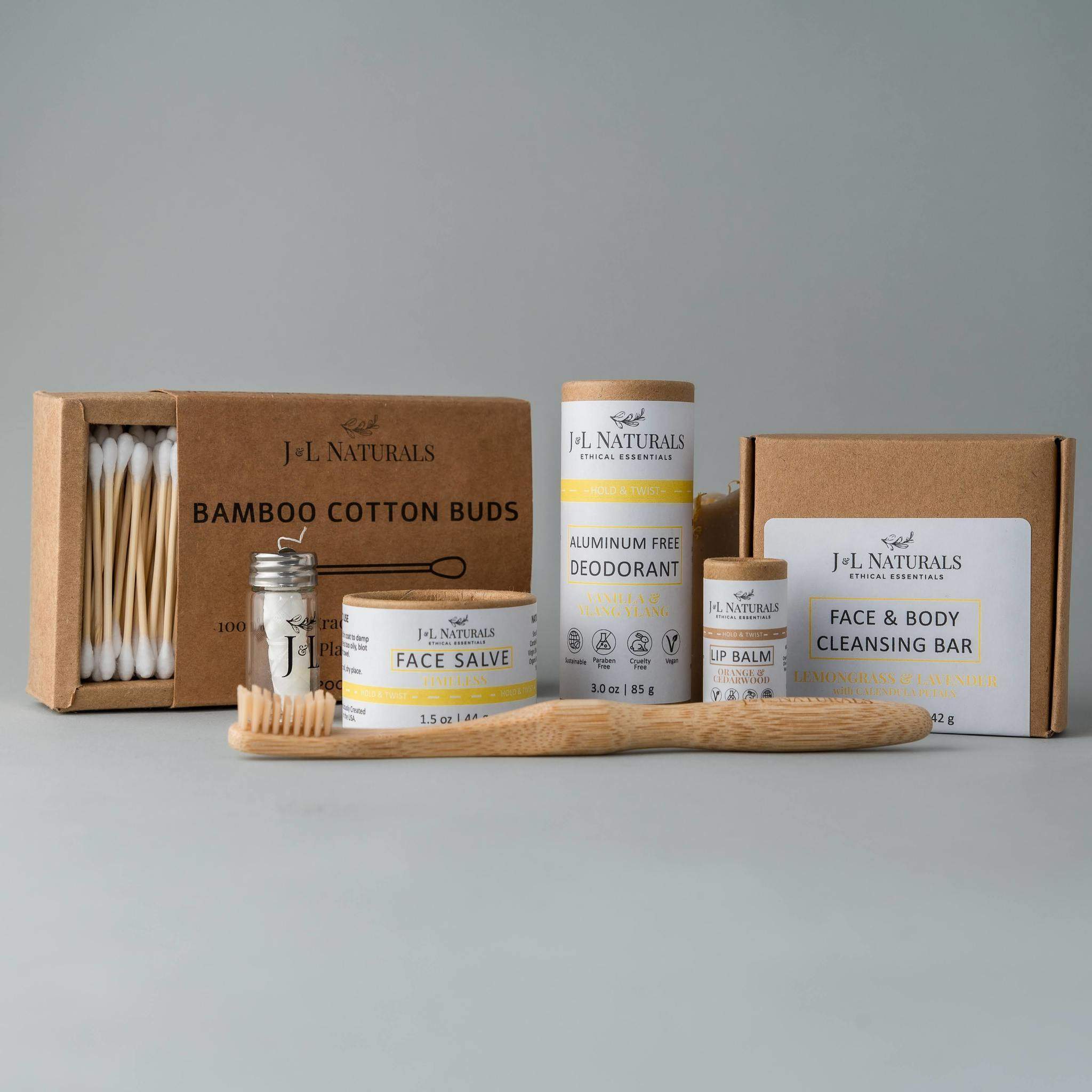 Essentials Self Care Kit featuring 7 skincare products including cleansing bar, face salve, lip balm, deodorant, bamboo toothbrush, floss, and cotton buds.