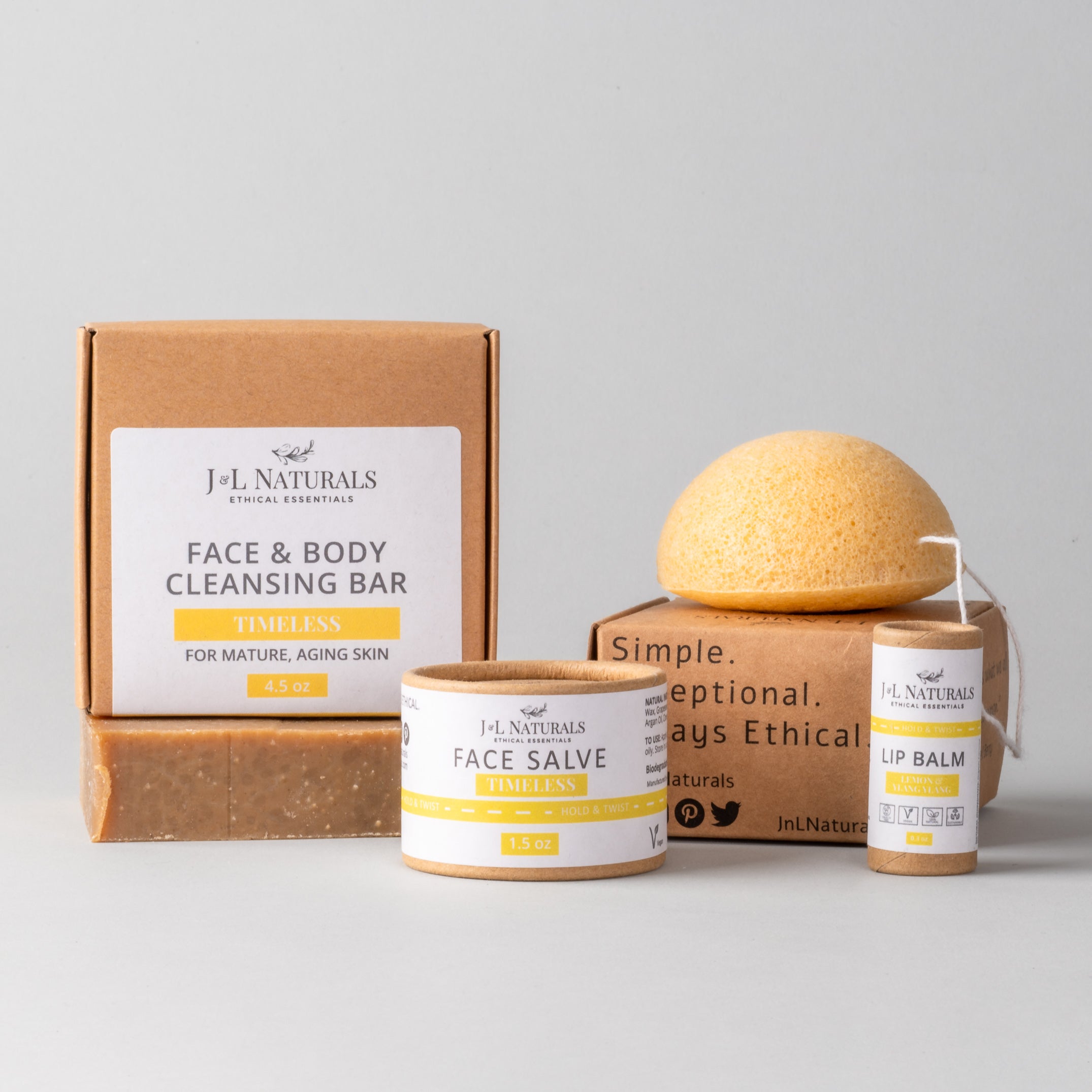 Essentials Skin Regimen Kit featuring a cleansing bar, konjac sponge, face salve, and lip balm in a stylish packaging.