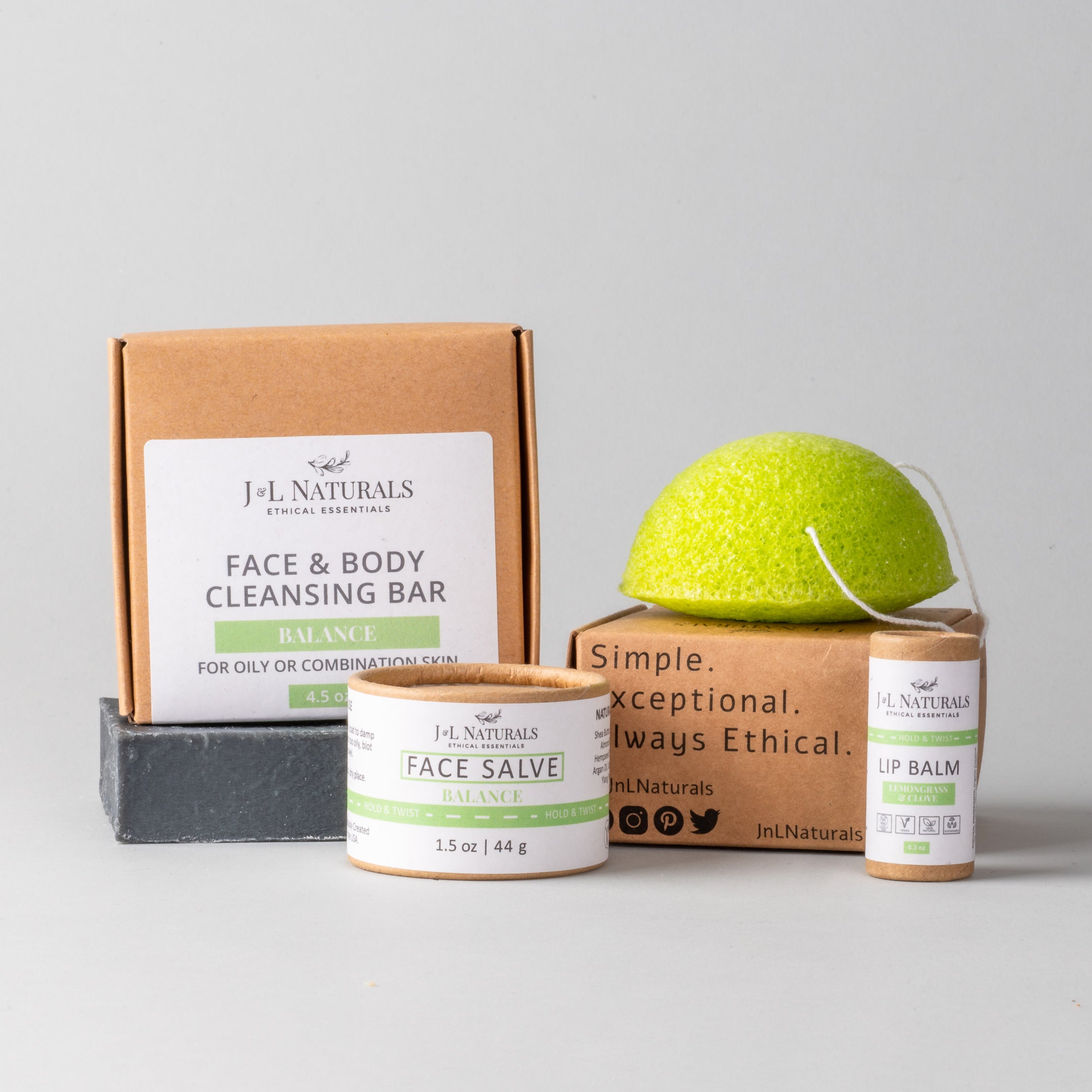 Essentials Skin Regimen Kit featuring a cleansing bar, konjac sponge, face salve, and lip balm in a stylish packaging.