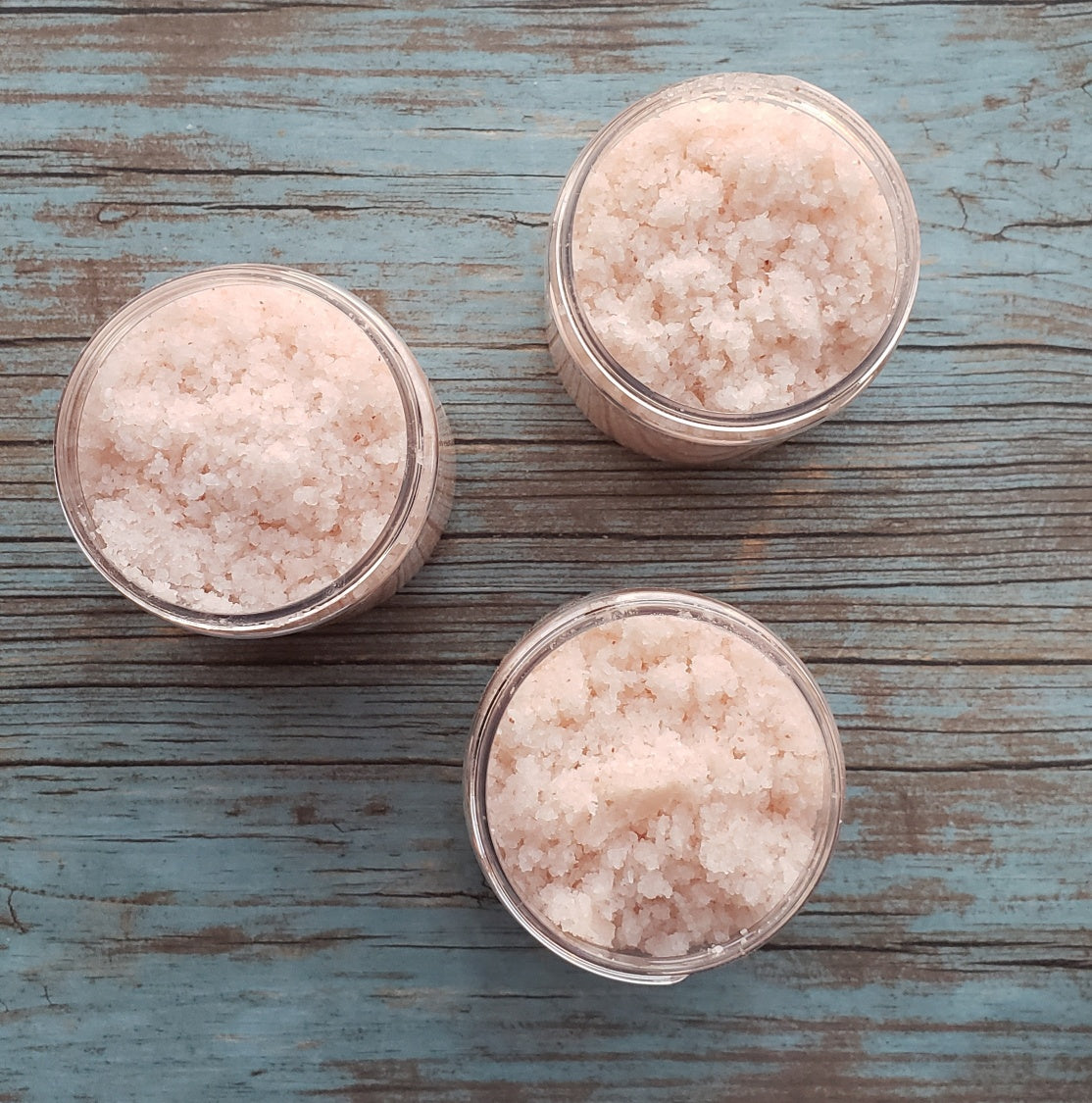 A jar of Eucalyptus Bath Salt with eucalyptus leaves and a wooden scoop, showcasing its natural ingredients and soothing properties.