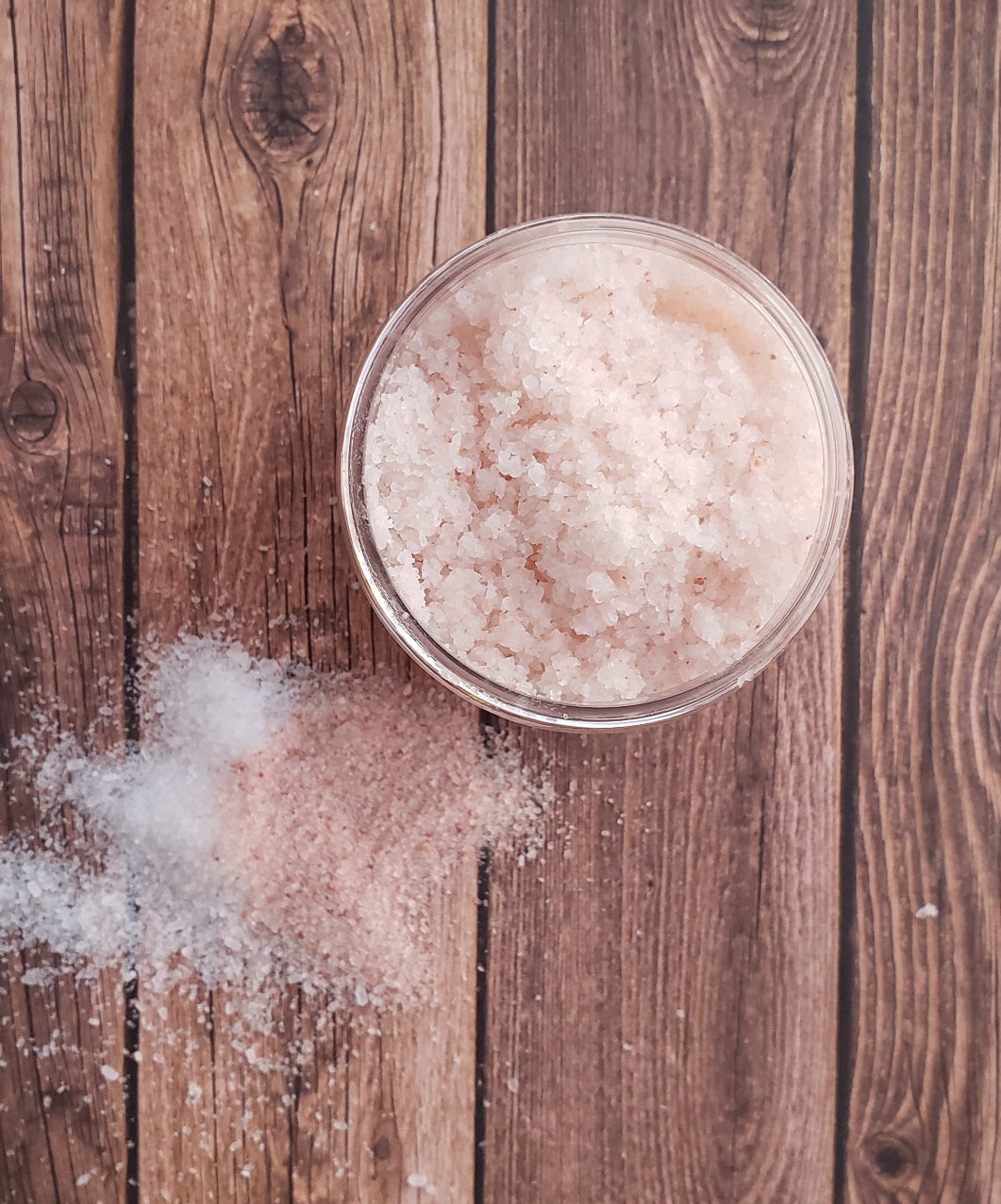 A jar of Eucalyptus Bath Salt with eucalyptus leaves and a wooden scoop, showcasing its natural ingredients and soothing properties.