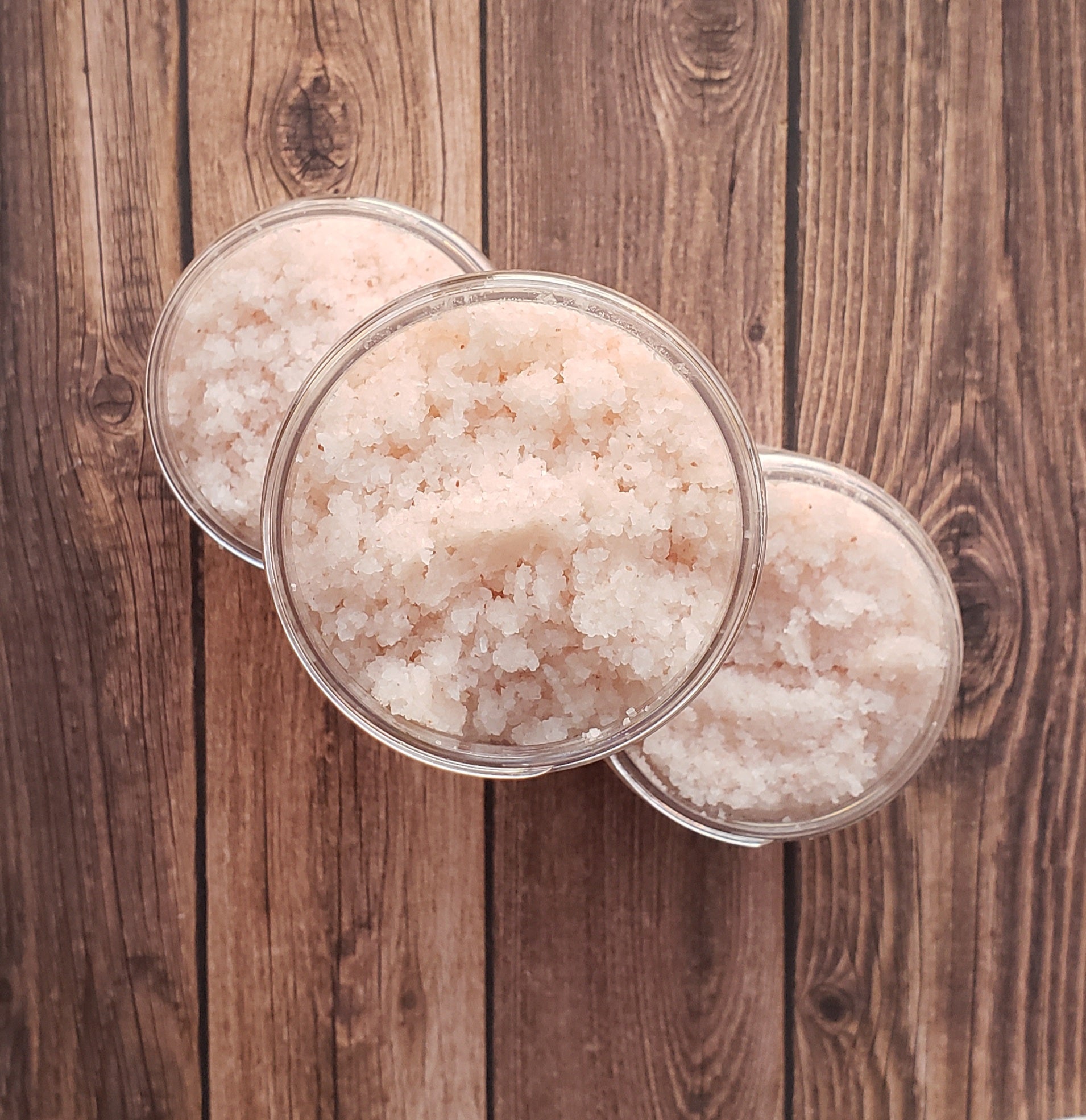 A jar of Eucalyptus Bath Salt with eucalyptus leaves and a wooden scoop, showcasing its natural ingredients and soothing properties.