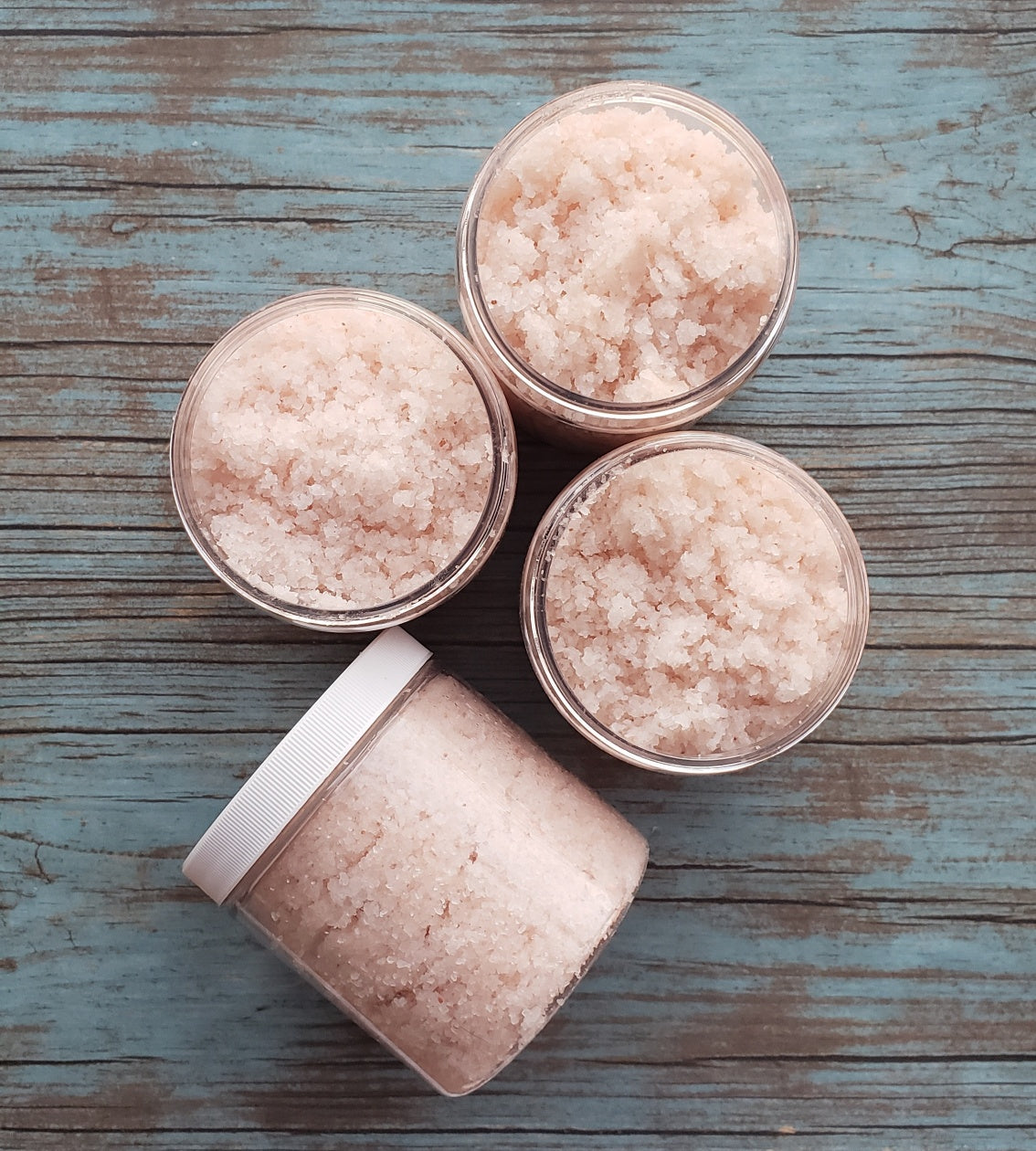 A jar of Eucalyptus Bath Salt with eucalyptus leaves and a wooden scoop, showcasing its natural ingredients and soothing properties.