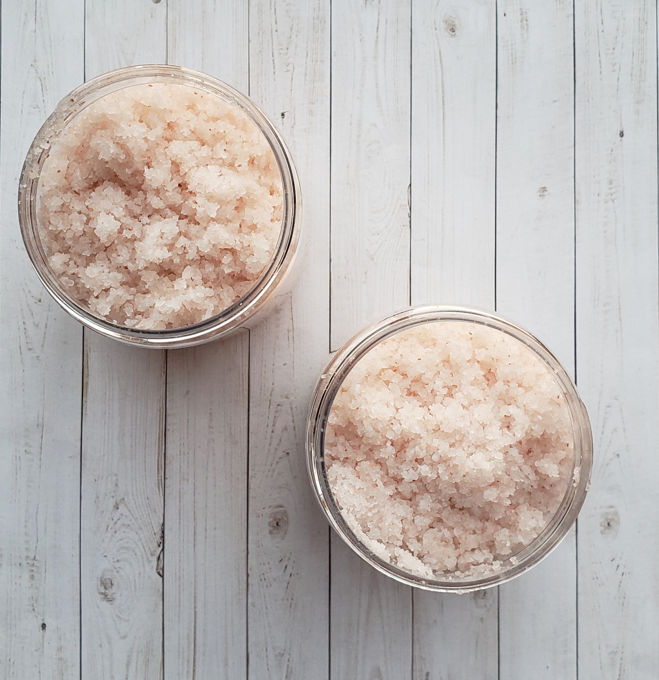 A jar of Eucalyptus Bath Salt with eucalyptus leaves and a wooden scoop, showcasing its natural ingredients and soothing properties.