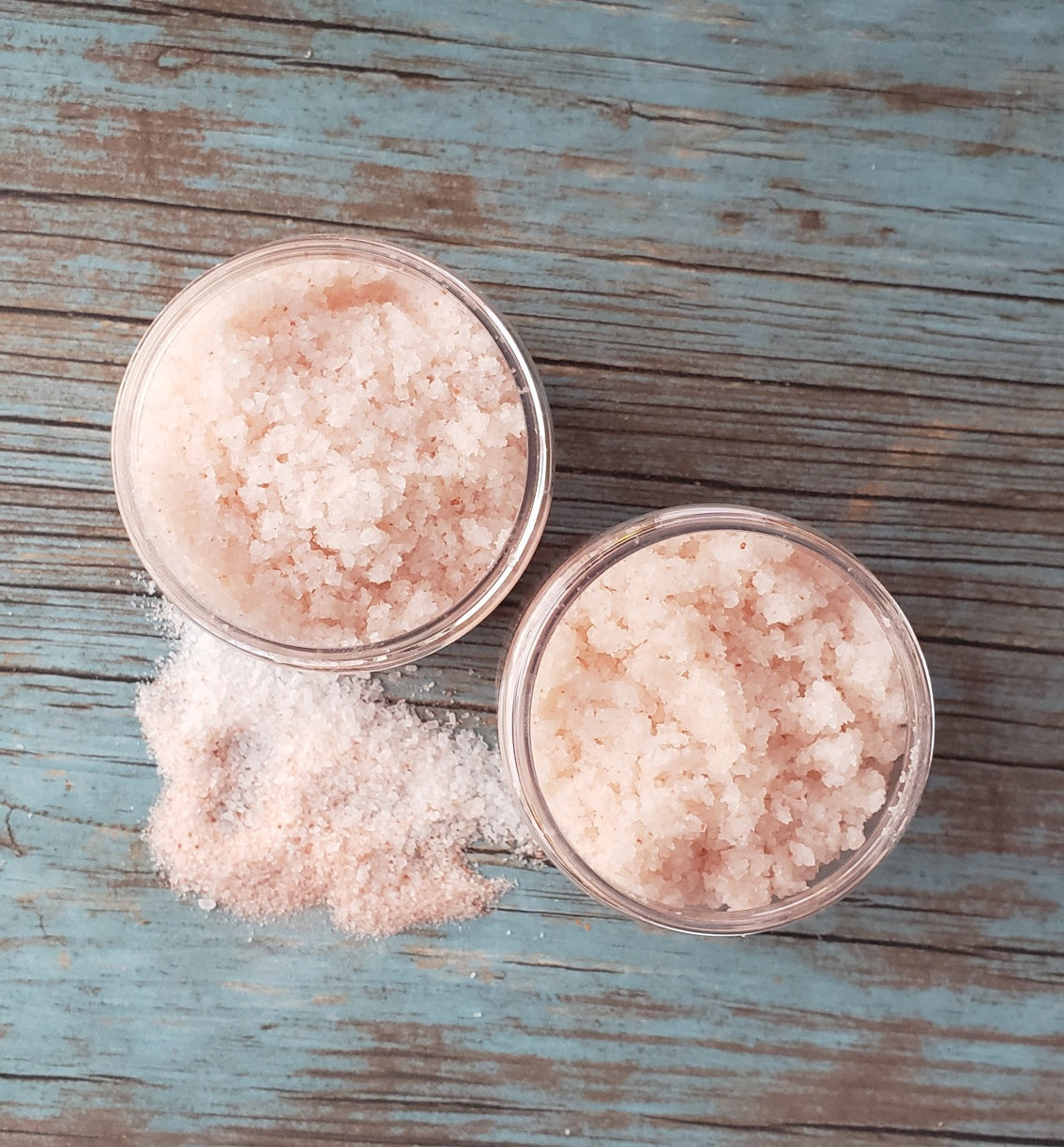 A jar of Eucalyptus Bath Salt with eucalyptus leaves and a wooden scoop, showcasing its natural ingredients and soothing properties.