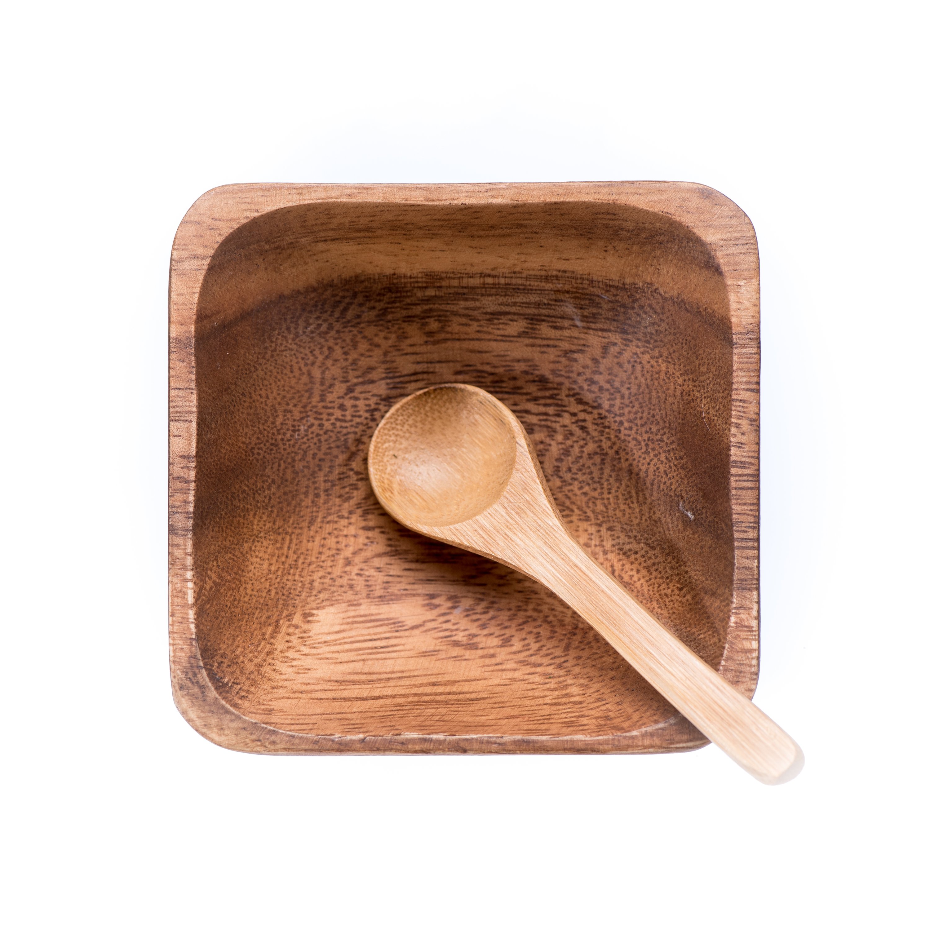 Eco-friendly bamboo spoon and acacia bowl for mixing skincare products, accompanied by a muslin travel pouch.