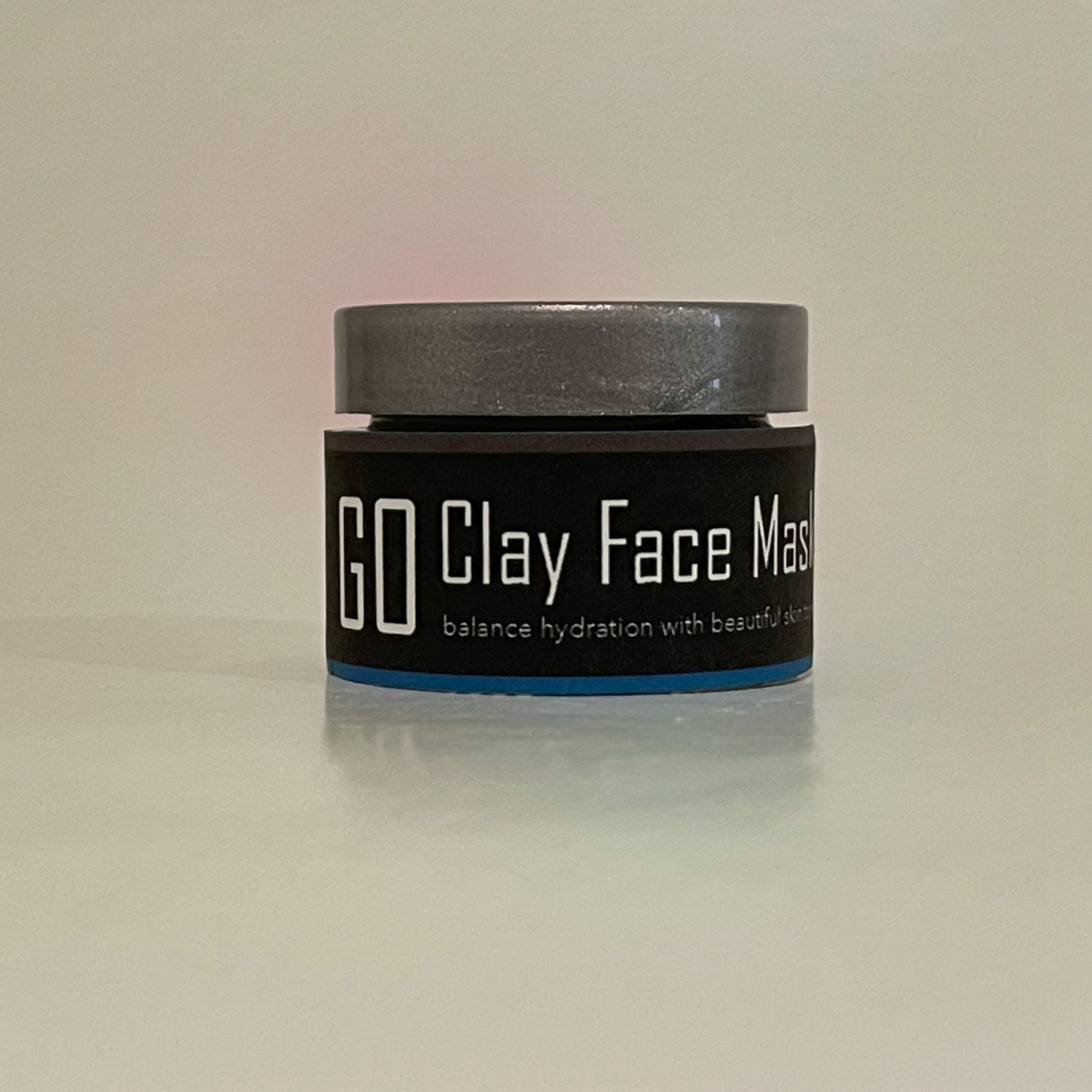 GO Clay Mask in a jar, showcasing its smooth grey texture and natural ingredients, perfect for rejuvenating and soothing the skin.