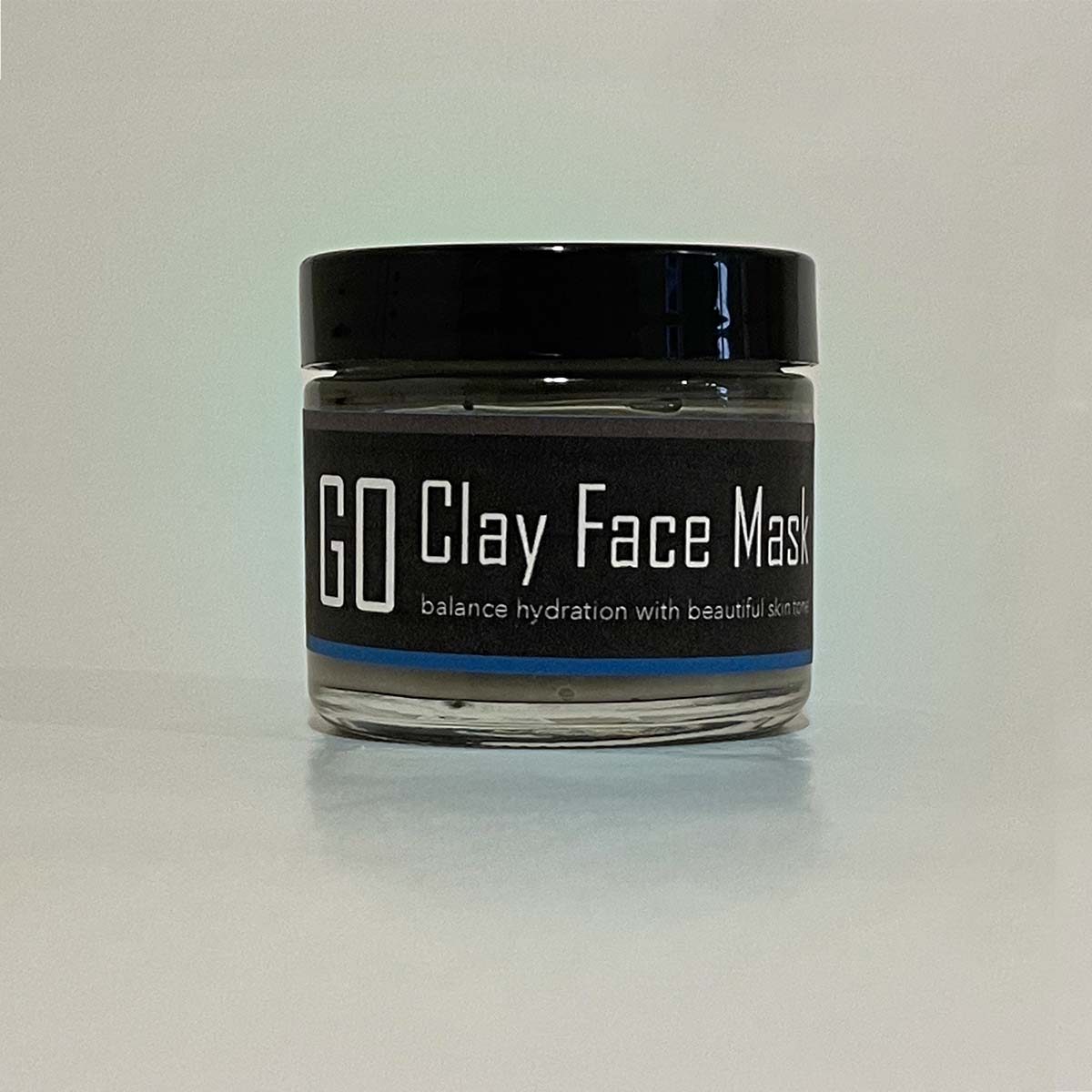 GO Clay Mask in a jar, showcasing its smooth grey texture and natural ingredients, perfect for rejuvenating and soothing the skin.