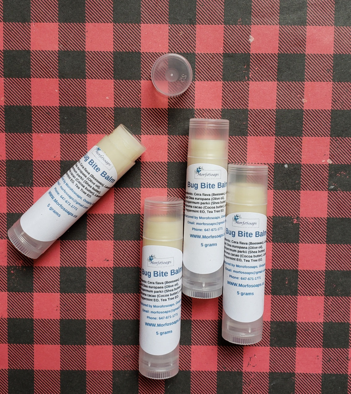 A small jar of Morfosoaps' Handmade Bug Bite Balm with a natural ingredients label, showcasing its soothing properties.