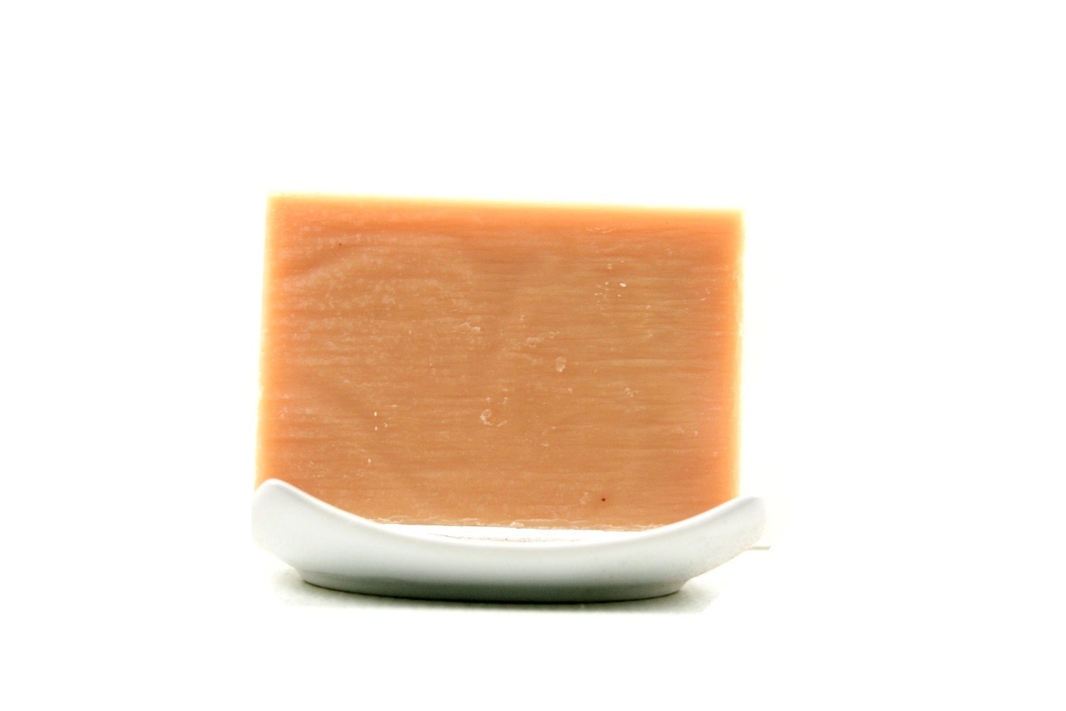 Karmic Gold Soap bar with essential oils, featuring a blend of patchouli, orange, lavender, pine, and lemongrass, displayed on a natural background.