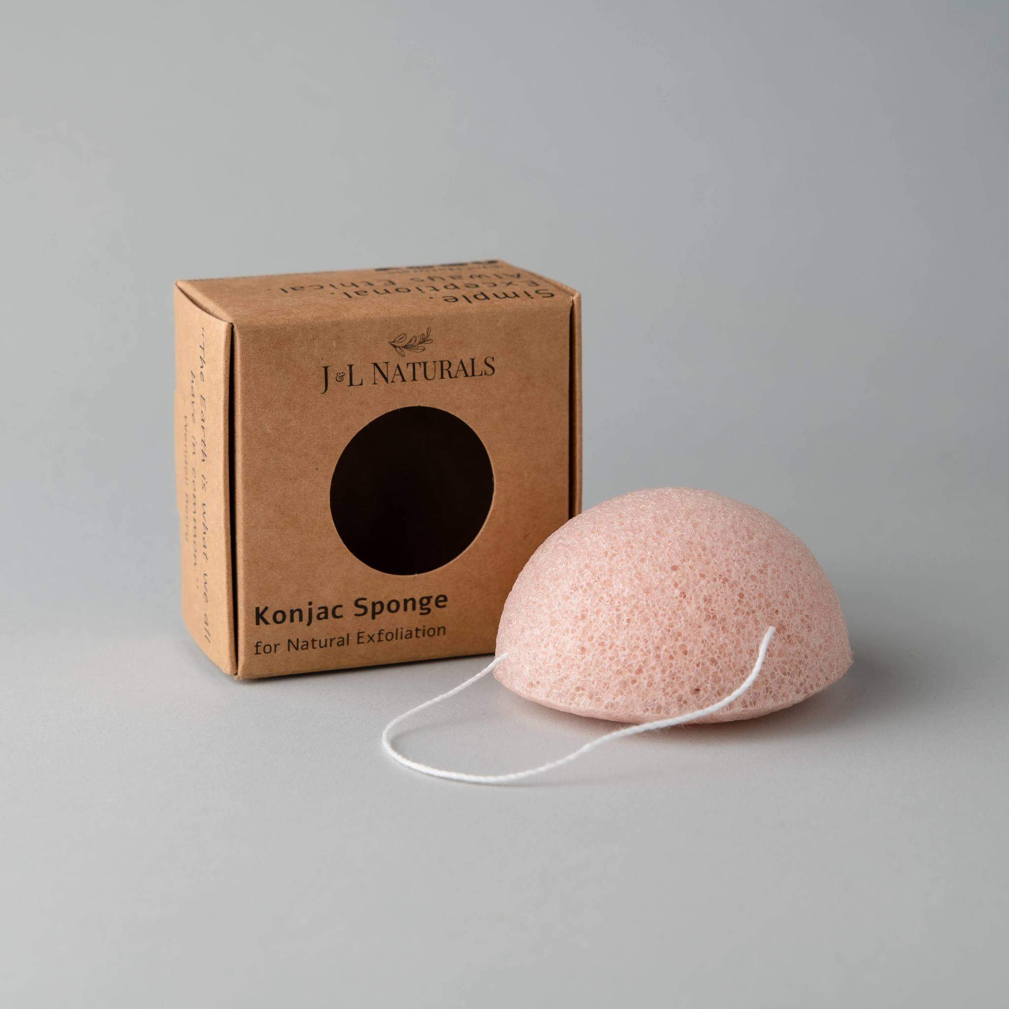 A collection of five biodegradable Konjac sponges in various colors, each representing different skin benefits, displayed on a natural wooden surface.