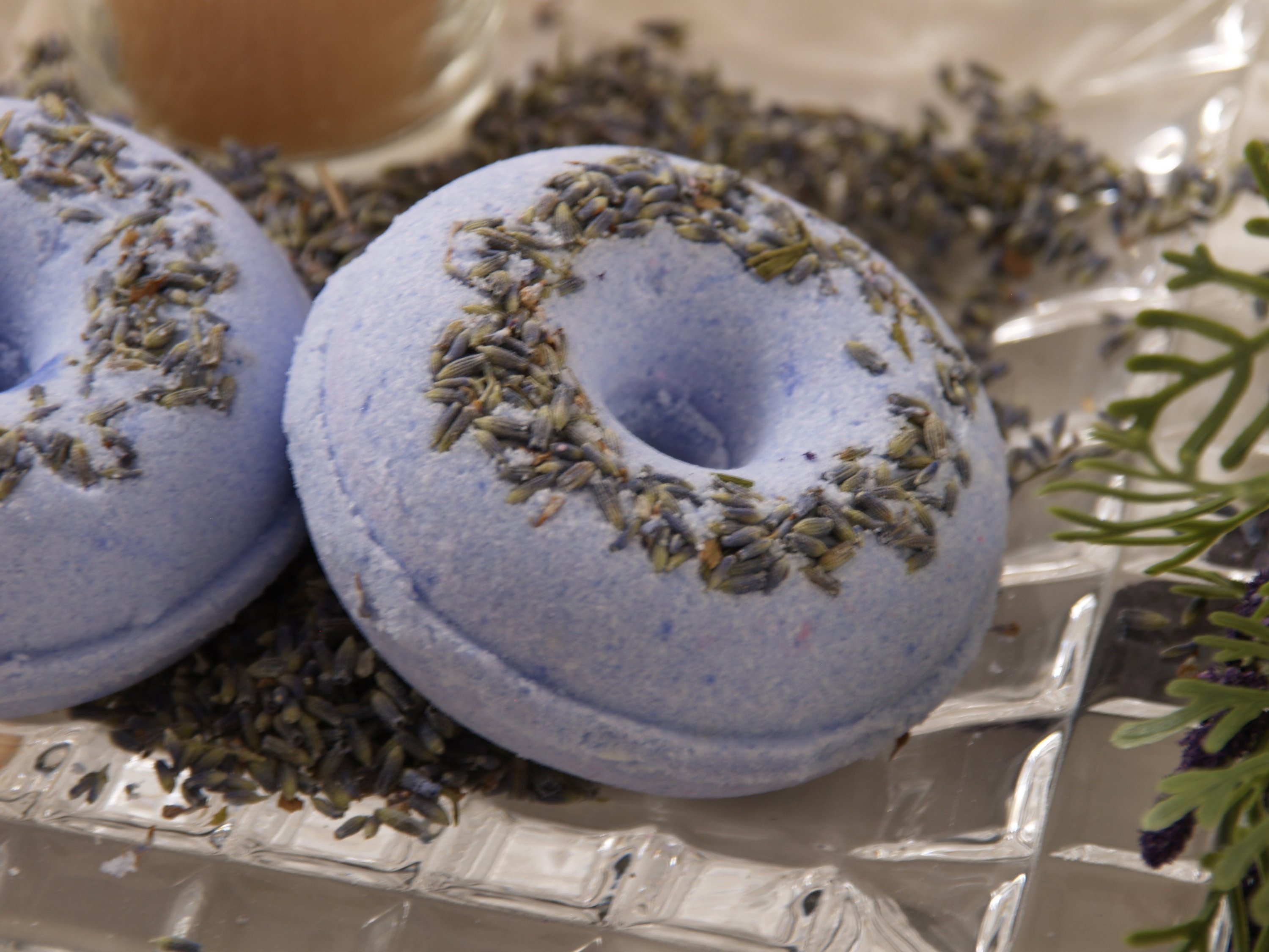 Lavender Blossom Bath Bomb in vibrant colors, surrounded by lavender petals, showcasing its luxurious and soothing properties.