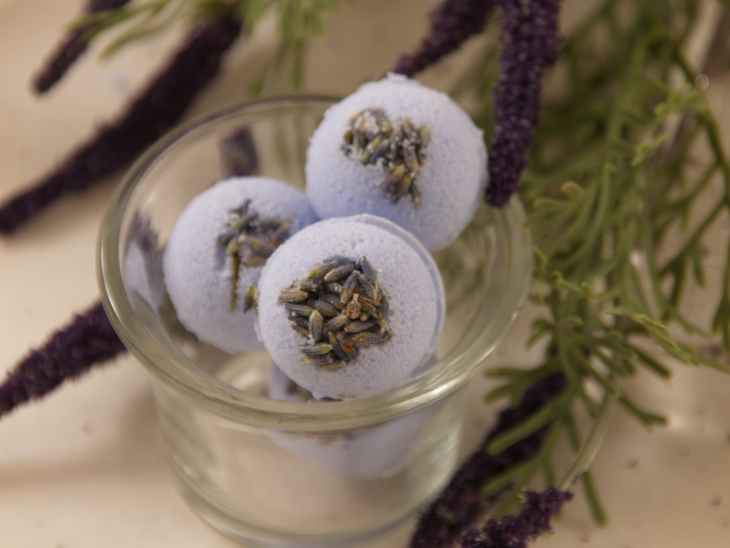 Lavender Blossom Bath Bomb in vibrant colors, surrounded by lavender petals, showcasing its luxurious and soothing properties.