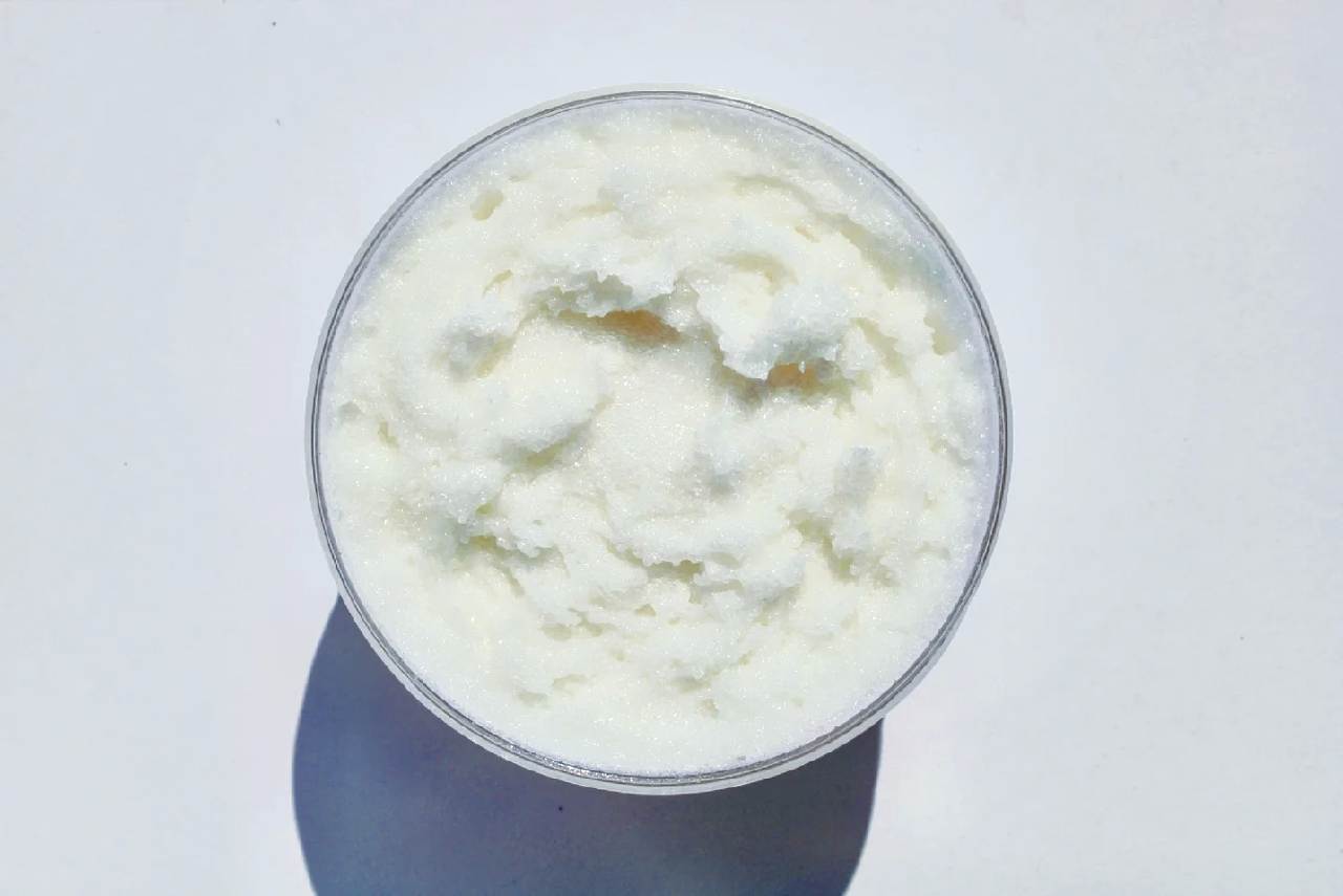 A jar of Lavender Martini Sugar Scrub with a whipped foaming texture, showcasing its lavender color and sugar granules, perfect for exfoliating and hydrating skin.