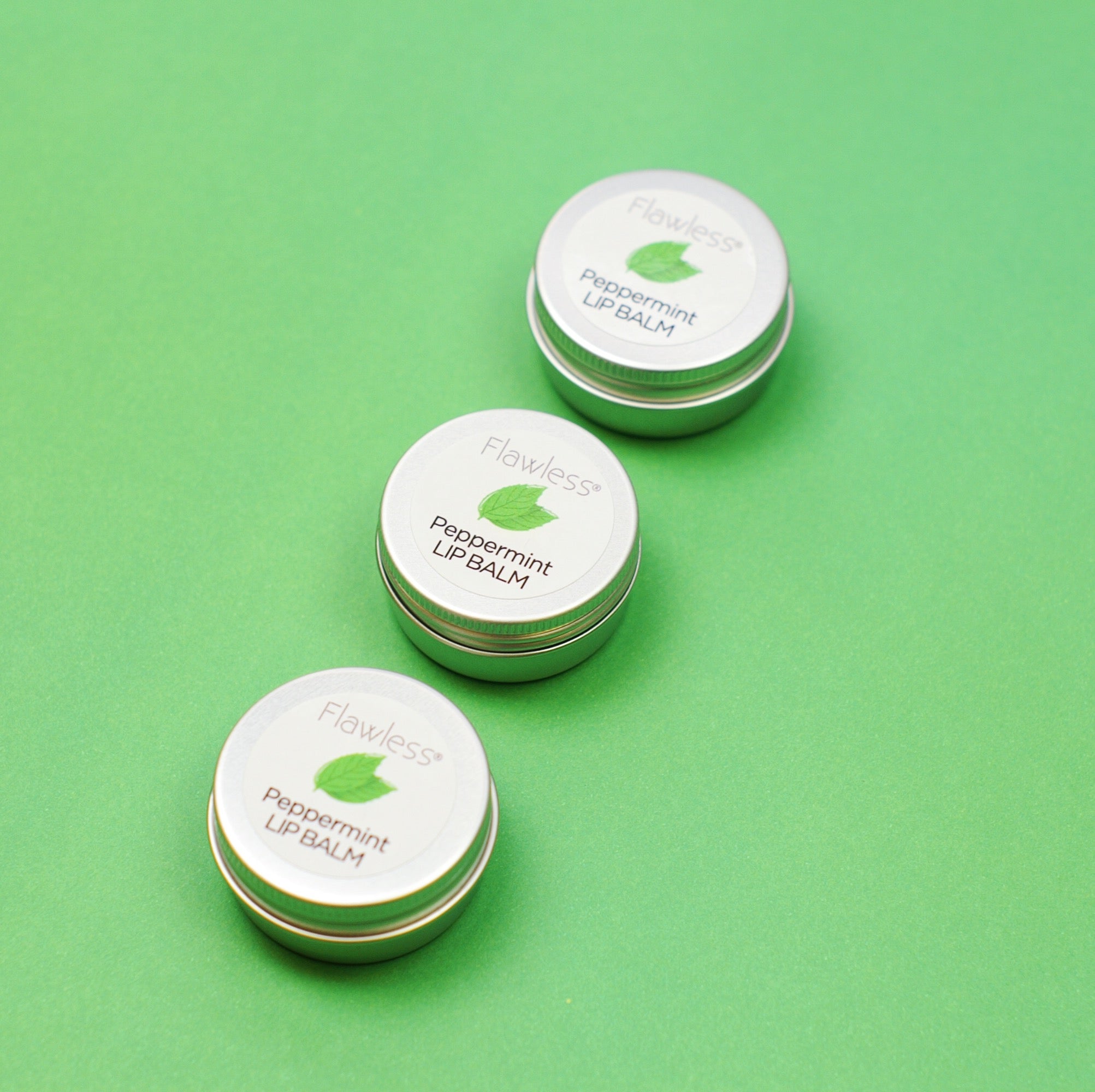 A tin of Peppermint Lip Balm featuring a minty green color, showcasing its eco-friendly packaging and natural ingredients.