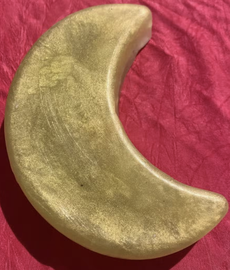 Golden crescent object on fabric