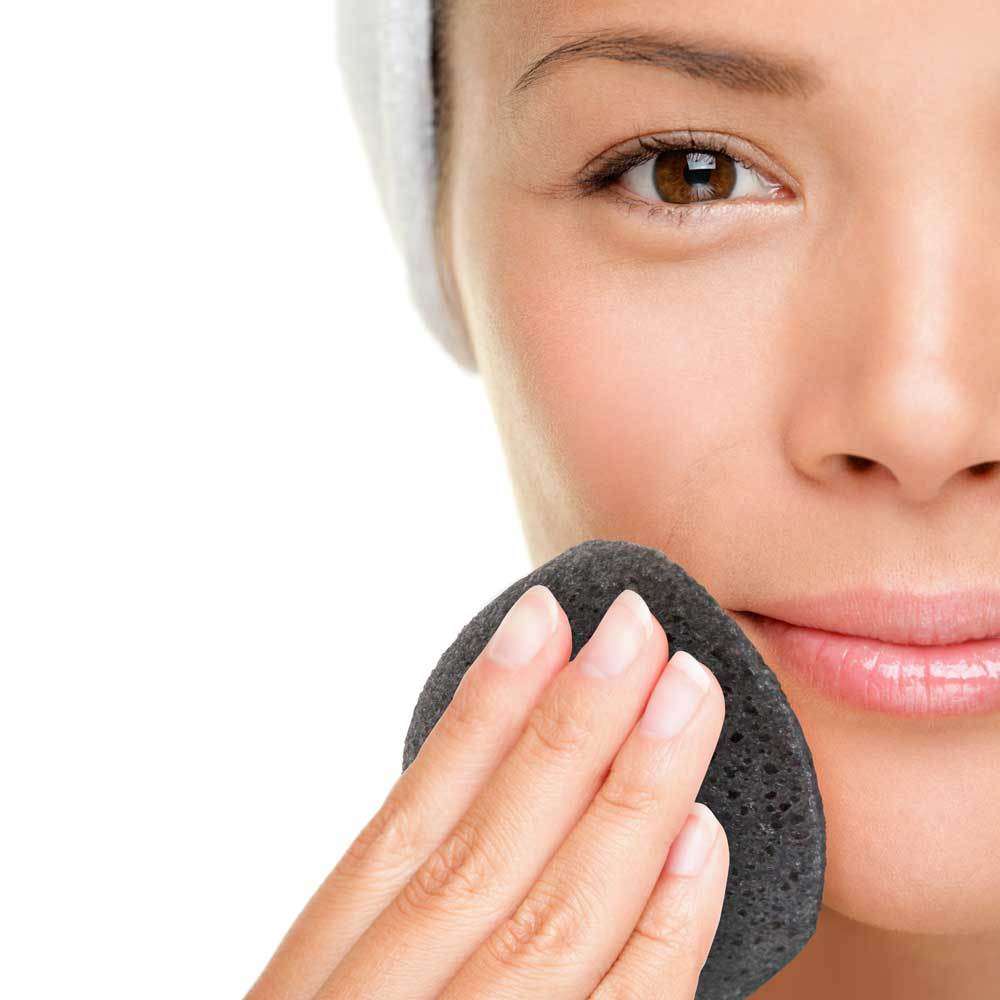 Natural Black Konjac Facial Sponge made from konjac root and bamboo charcoal, ideal for oily and acne-prone skin, shown wet and ready for use.