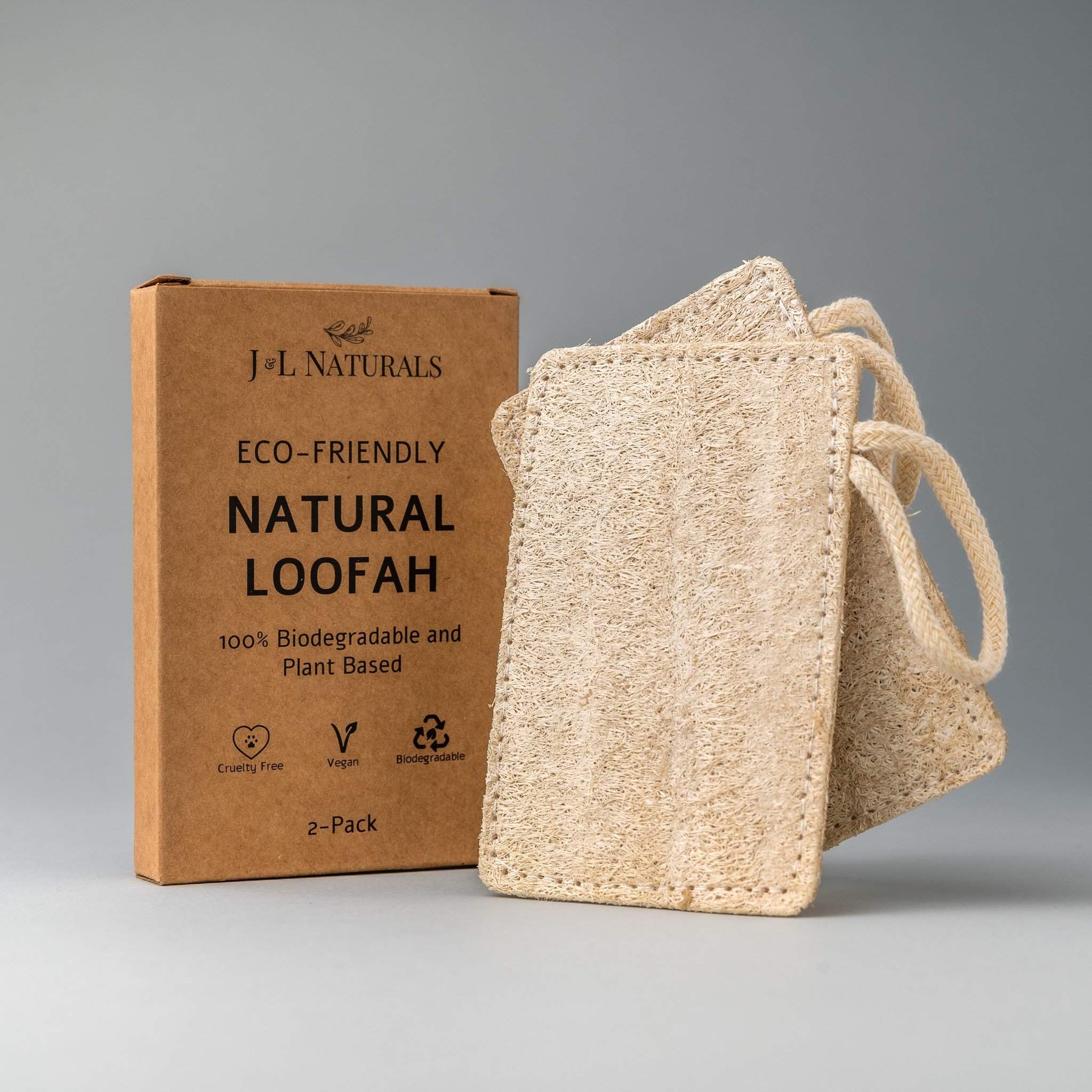 Two natural loofah pads on a wooden surface, showcasing their texture and eco-friendly design.