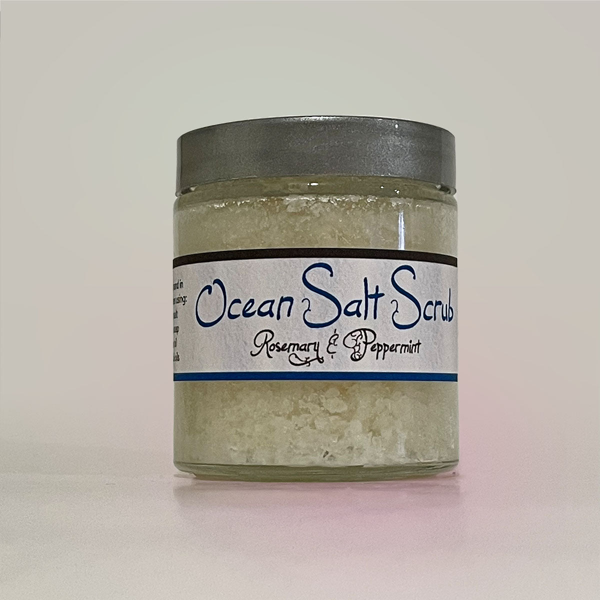 Ocean Salt Scrub with Rosemary and Peppermint in a clear jar, showcasing its textured salt and vibrant colors.