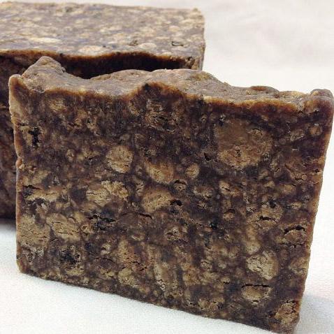 A bar of Organic African Black Soap with a rich, dark color, showcasing its natural texture and ingredients.