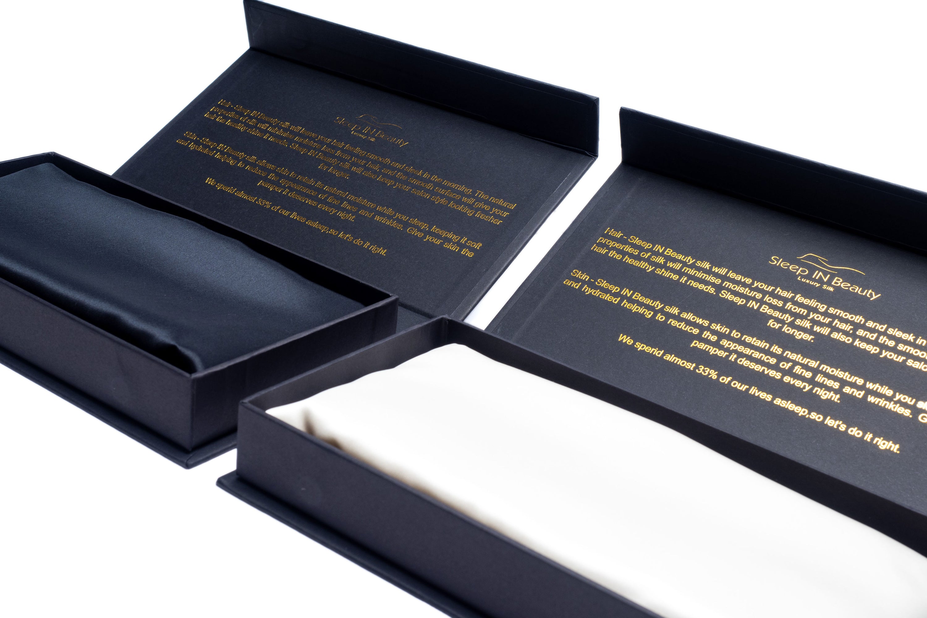 A pair of luxurious SIB™ silk pillowcases in elegant black and gold gift boxes, showcasing their soft texture and hidden zipper design.